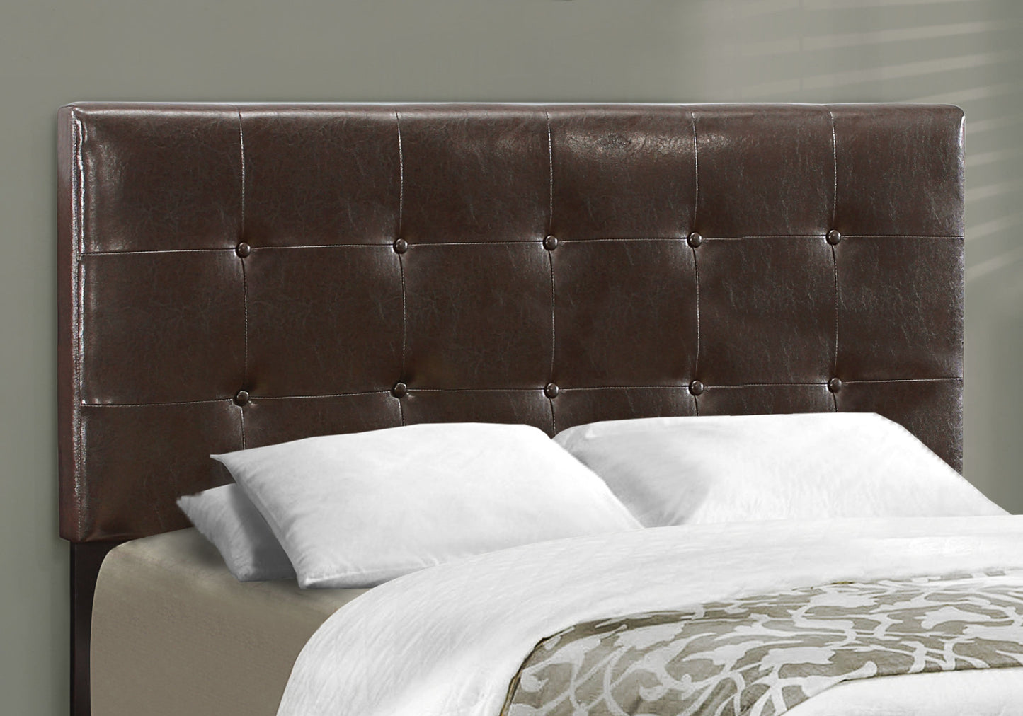 Tufted dark brown faux leather headboard with silver nailhead trim