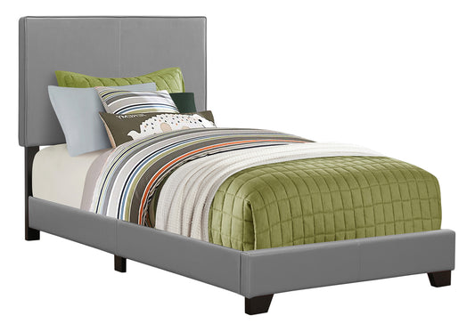 Gray upholstered twin bed frame with a modern headboard and patterned bedding