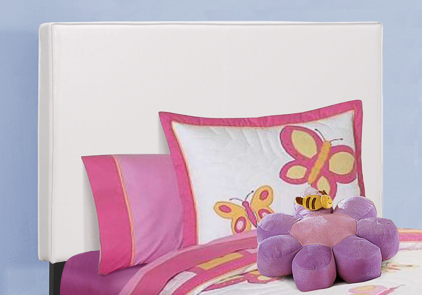 White upholstered headboard with pink butterfly comforter and pillow set