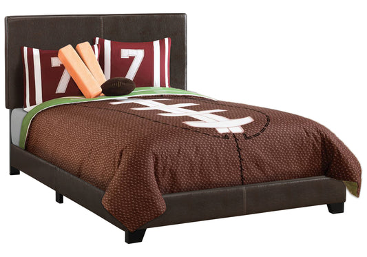 Brown leather upholstered bed frame with footballthemed bedding and accent pillows