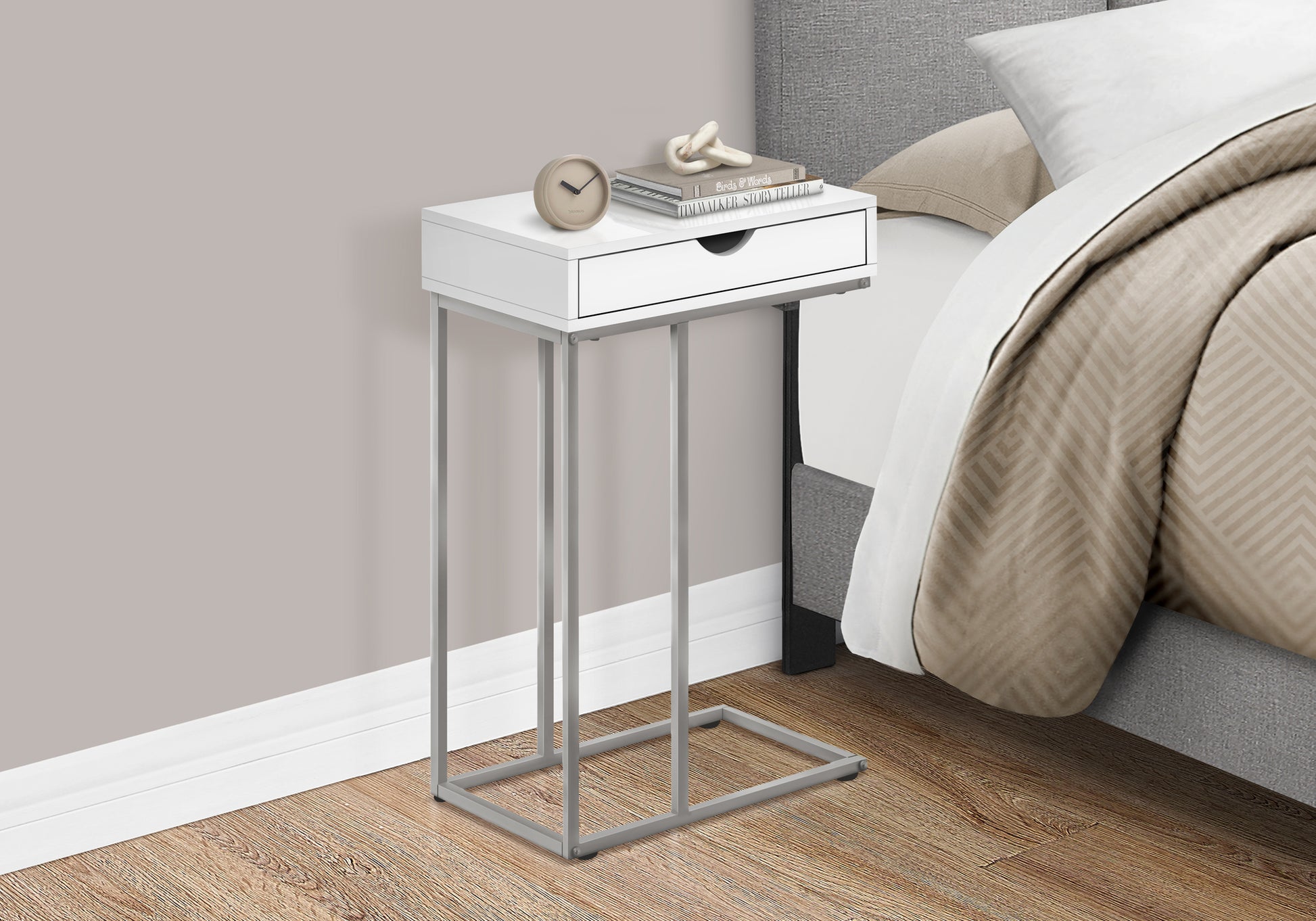 White ctable with silver metal frame featuring a drawer and bedside decor