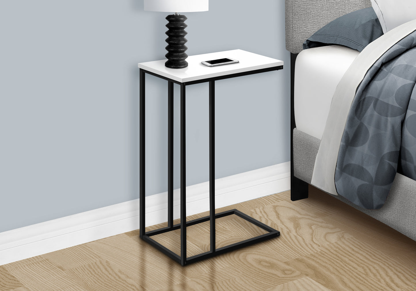 White and black metal Ctable with a smartphone and lamp perfect for bedside organization