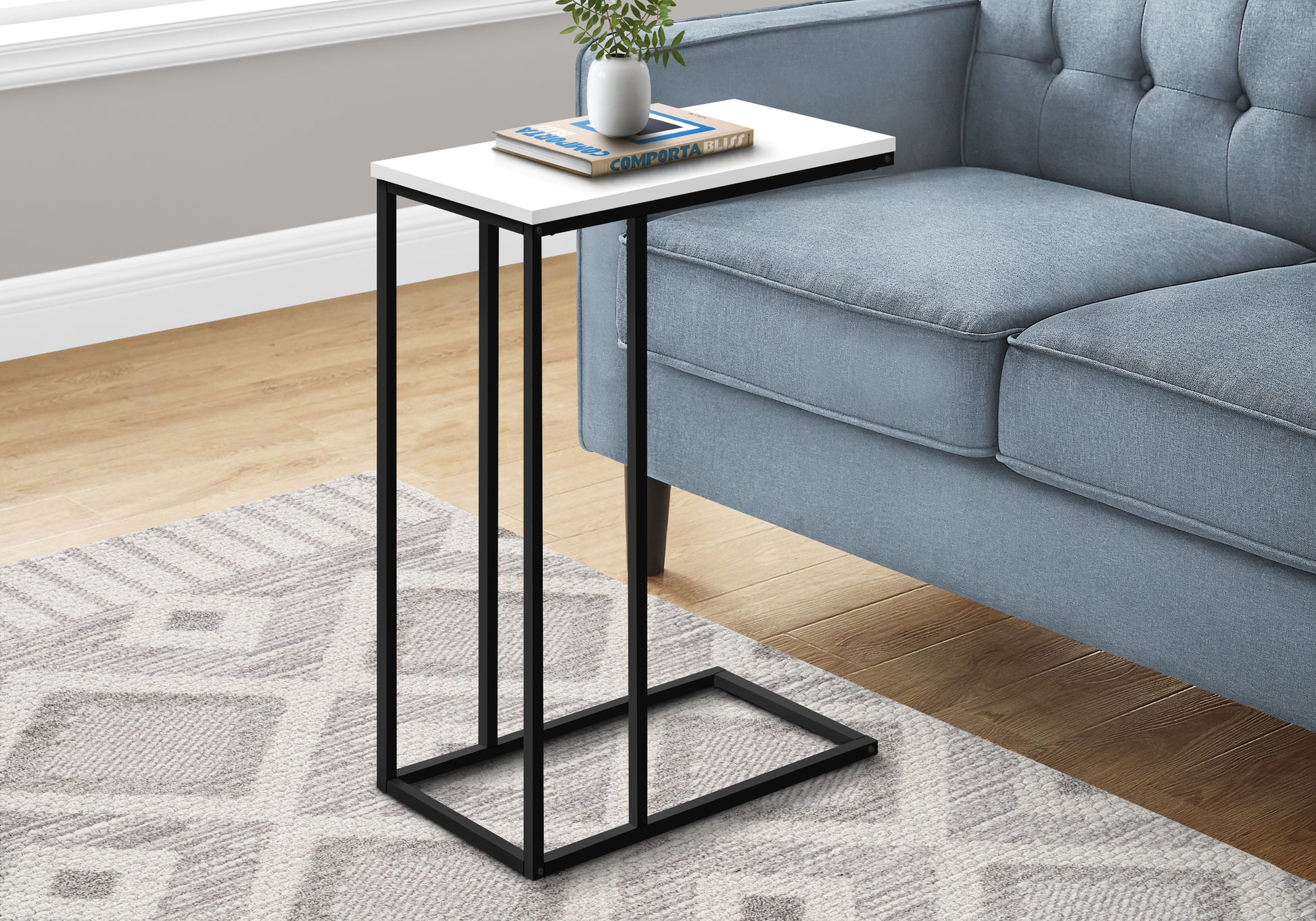 White marble top ctable with black metal frame next to a blue sofa
