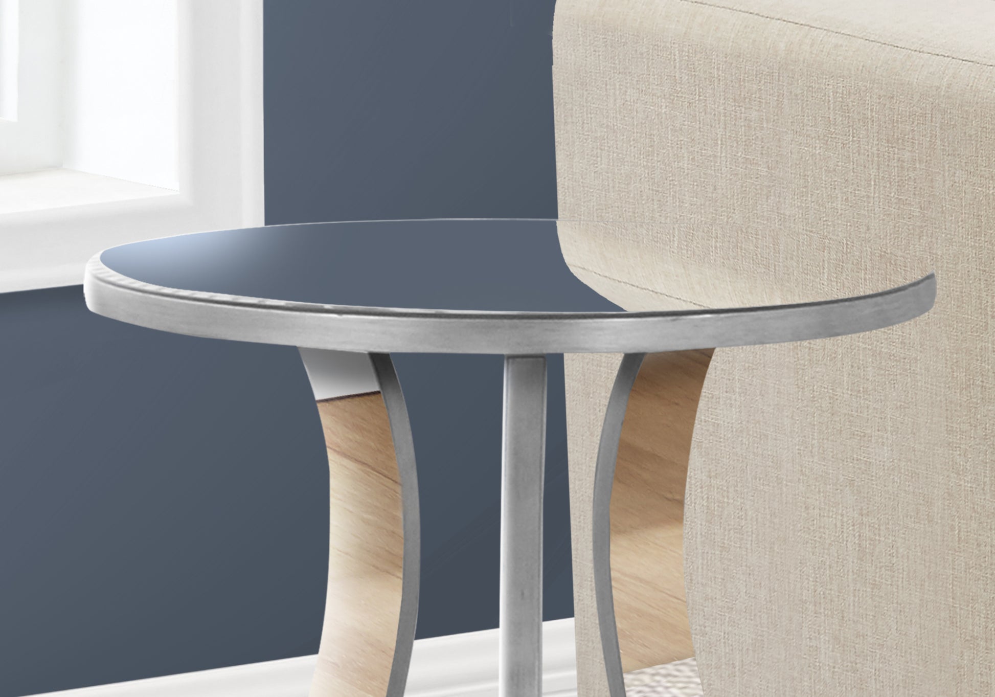 Round glass top accent table with metallic silver pedestal base and curved wood panel detail