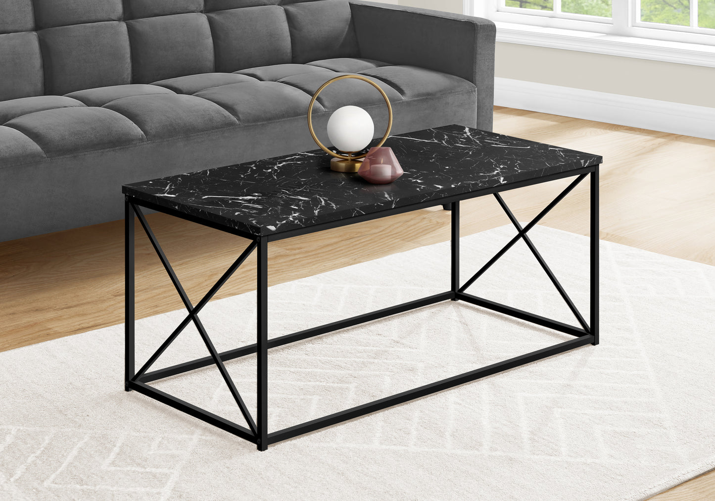 Black marble coffee table with matte black metal legs and an abstract white pattern