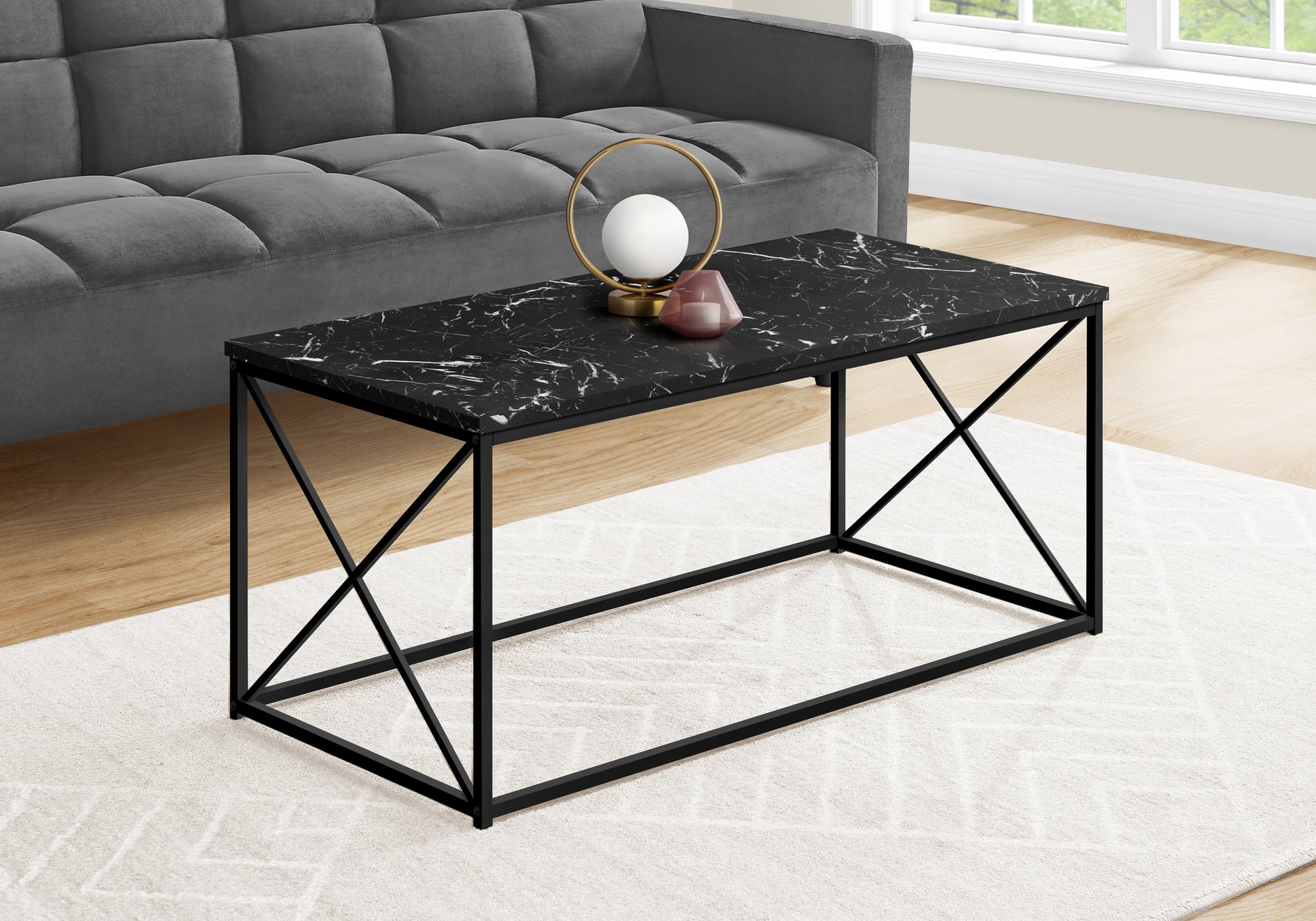 Black marble coffee table with matte black metal legs and an abstract white pattern