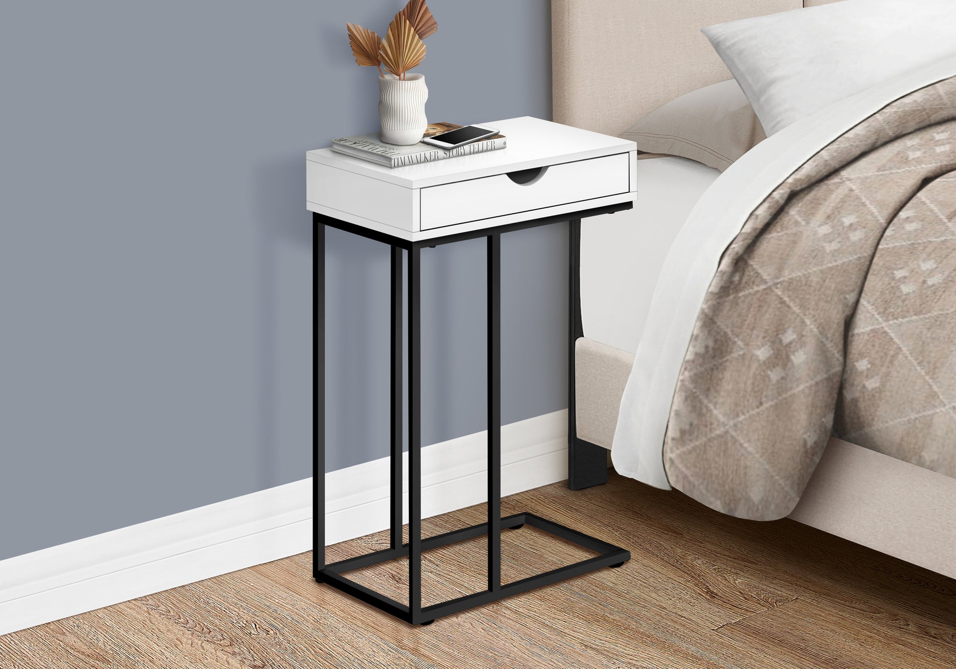 Modern white Ctable with a single drawer and black metal base by bedside