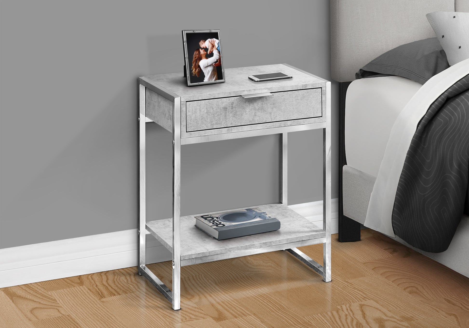 Modern bedside table with concrete finish and chrome legs featuring one drawer and open shelf