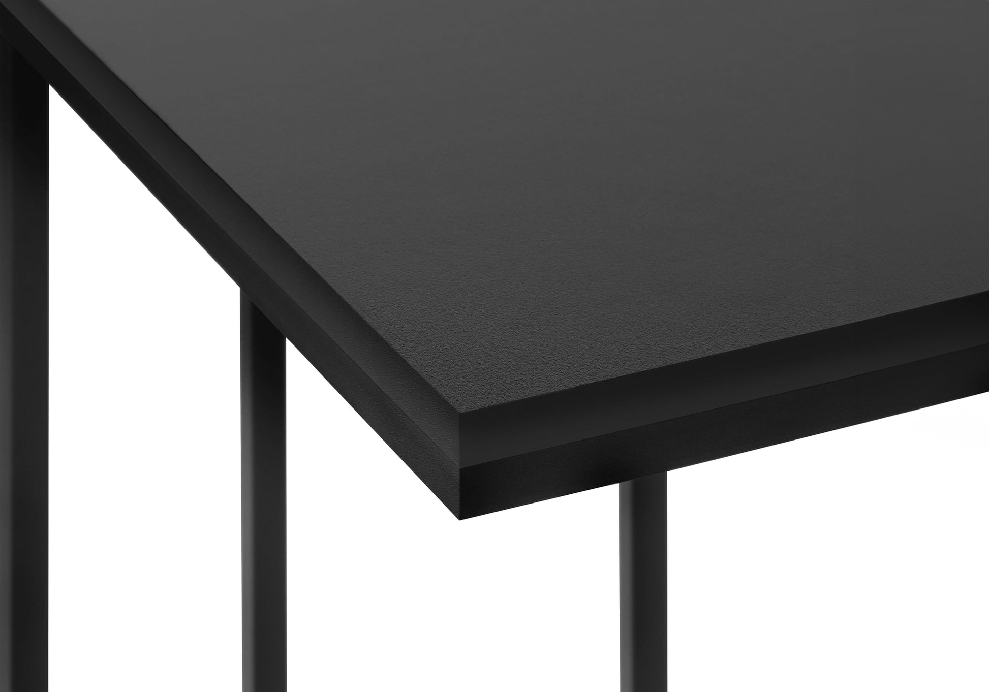 Closeup of a black metal frame side table with a textured dark gray tabletop surface