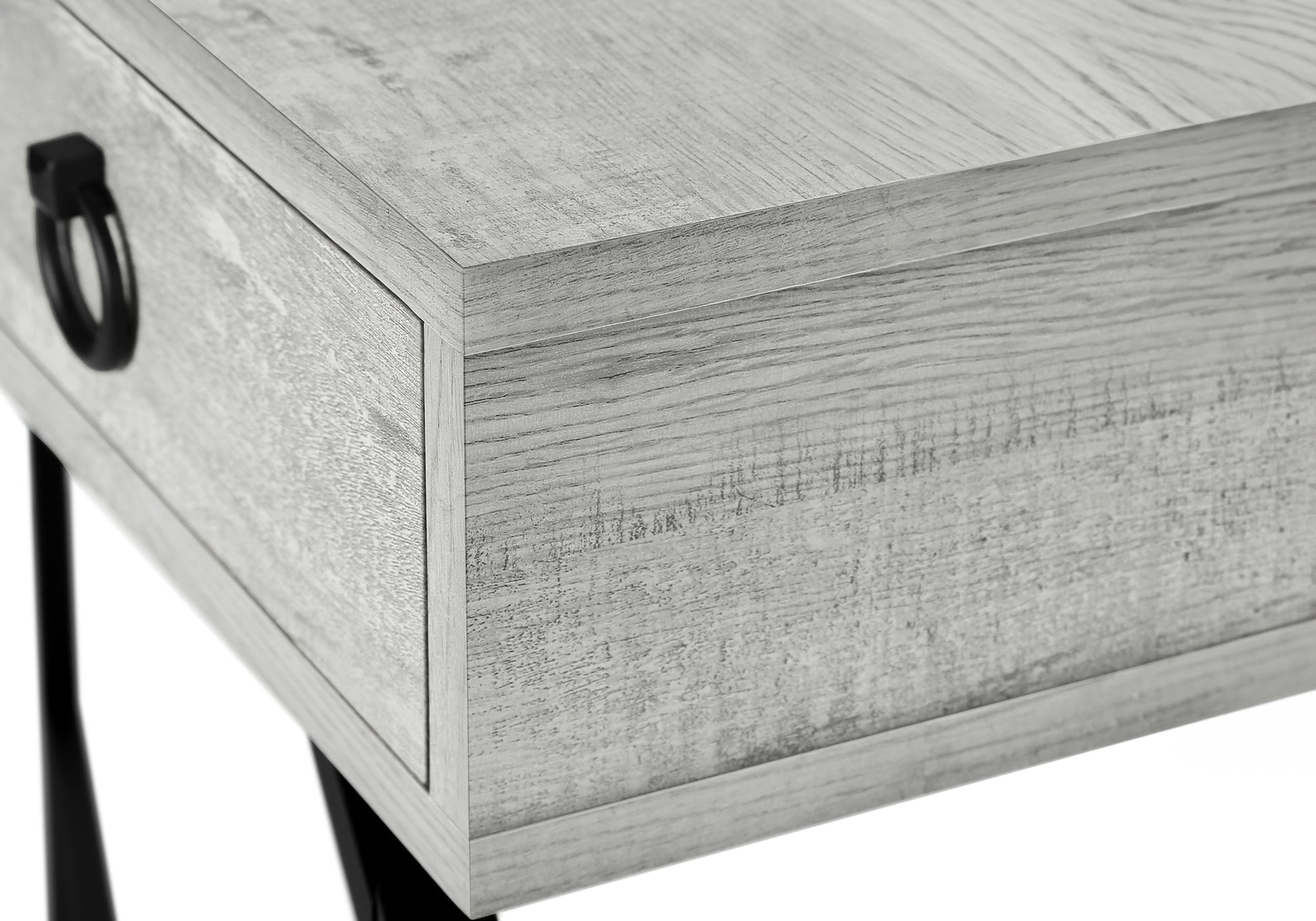 Close up of a grey weathered wood bedside table with a black ring pull drawer handle