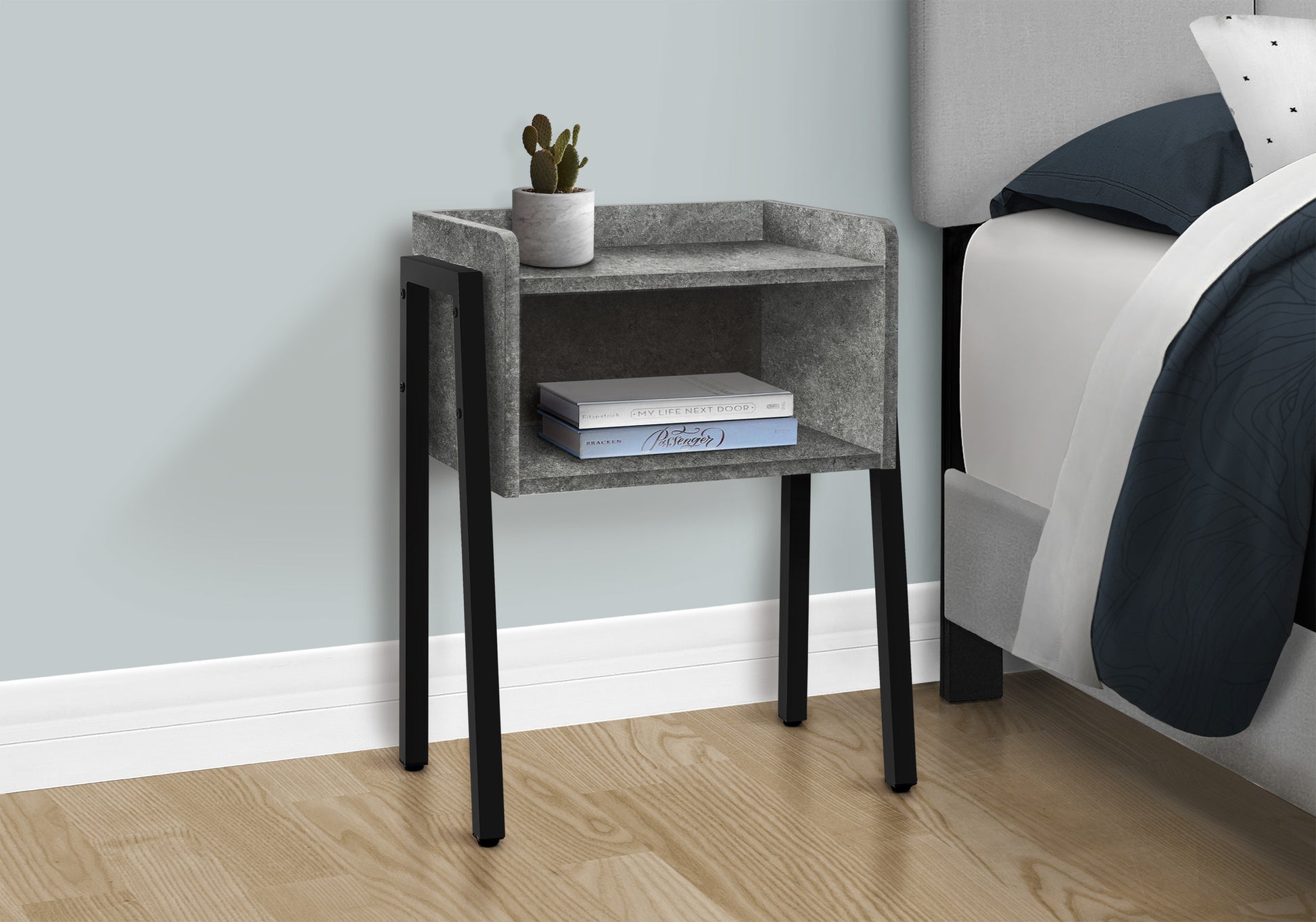 Gray textured nightstand with black metal legs and two shelves holding books and a plant