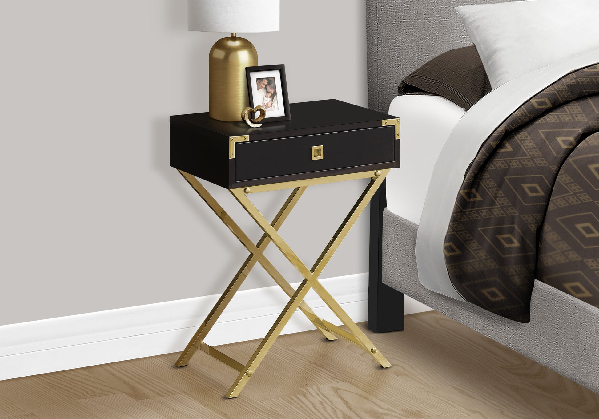 Black and gold bedside table with a single drawer and decorative hardware