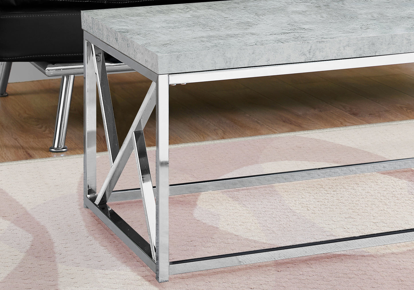 Gray concrete top coffee table with chrome legs and geometric accents