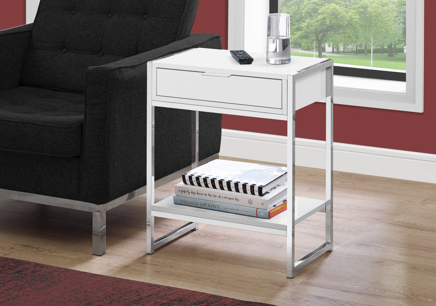Modern white bedside table with silver frame and drawer holding books