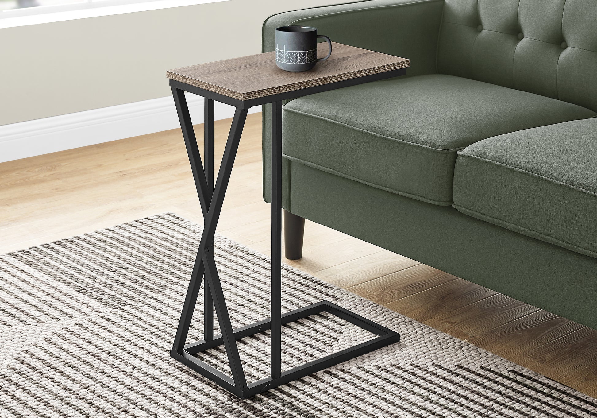 Modern Ctable with rustic oak top and black metal base next to green sofa