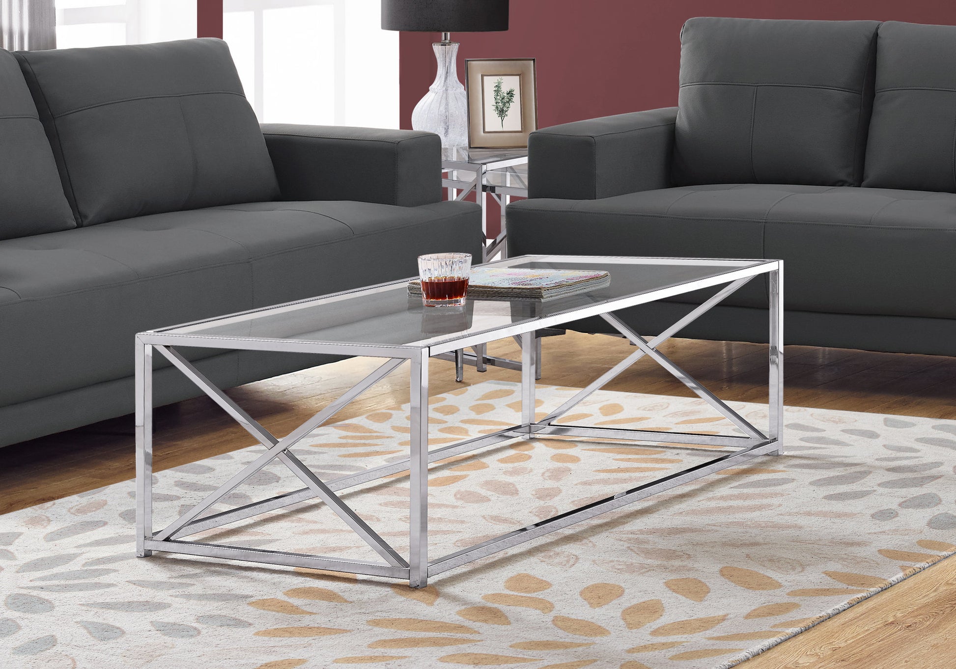 Rectangular glass coffee table with a polished chrome frame featuring geometric crisscross supports
