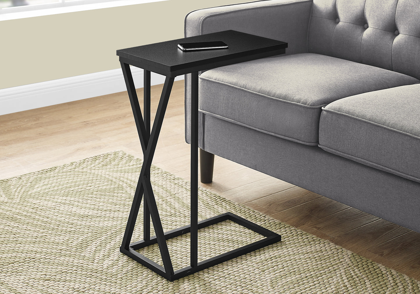 Sleek black ctable with unique twisted metal base and phone resting on tabletop