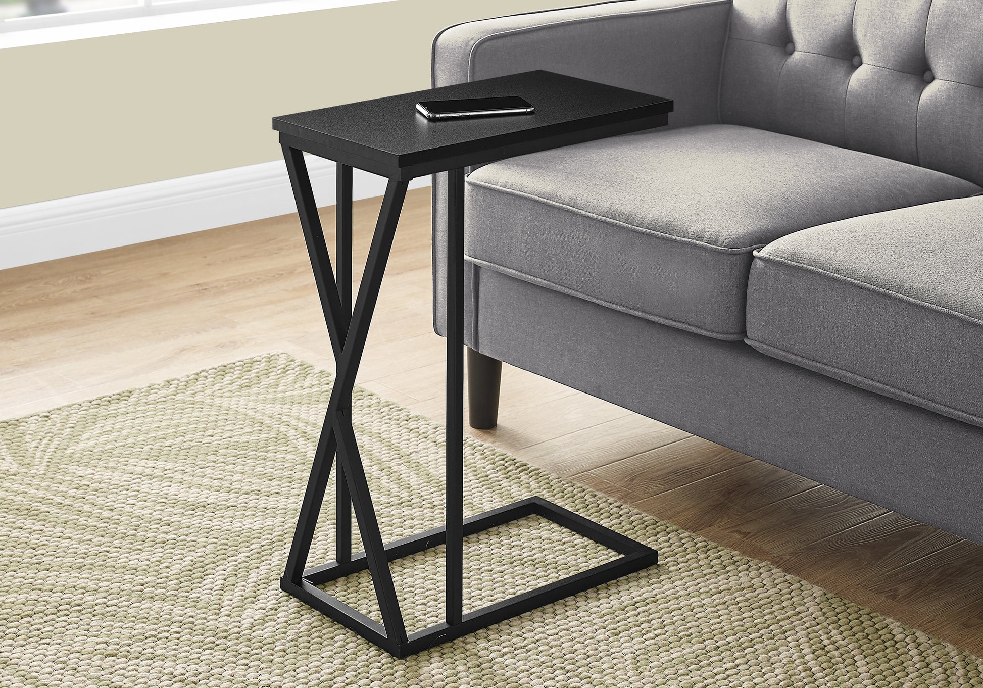 Sleek black ctable with unique twisted metal base and phone resting on tabletop