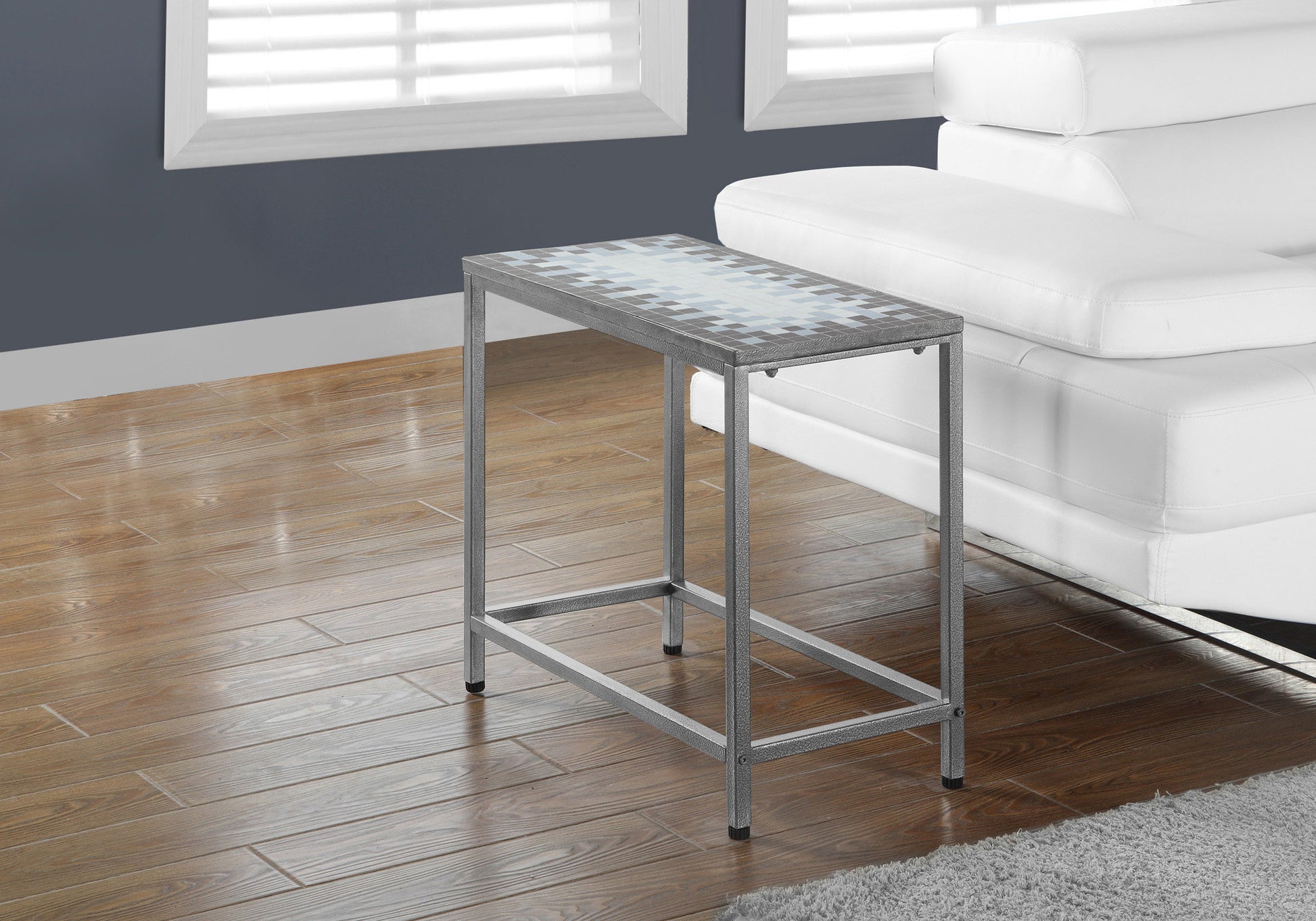Grey metal side table with a mosaic tile top featuring blue and white geometric patterns