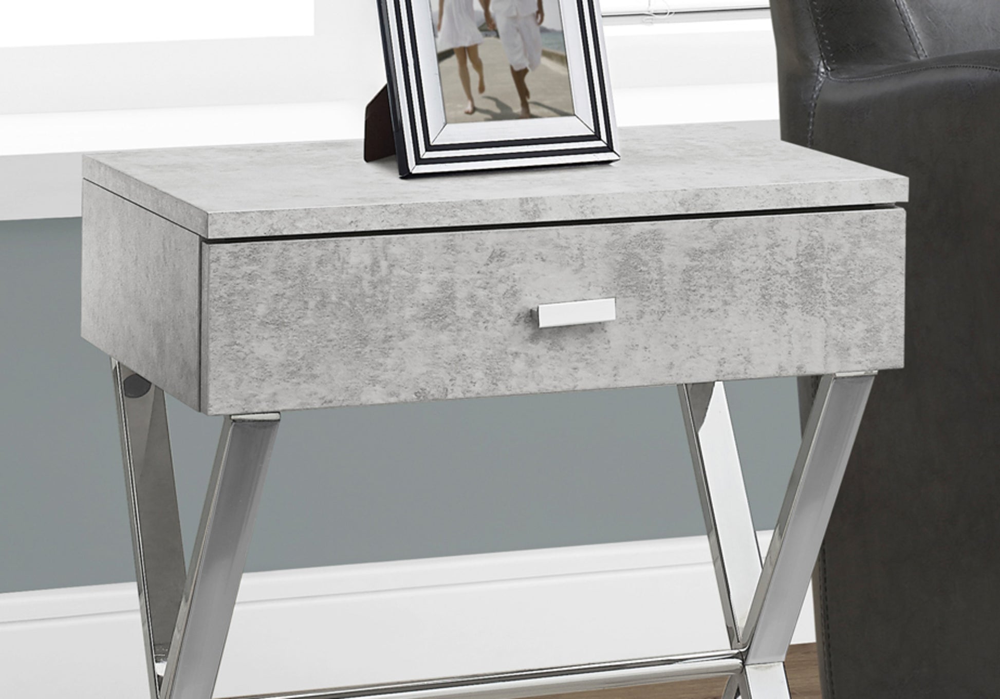 Gray concrete finish end table with polished chrome legs and one drawer