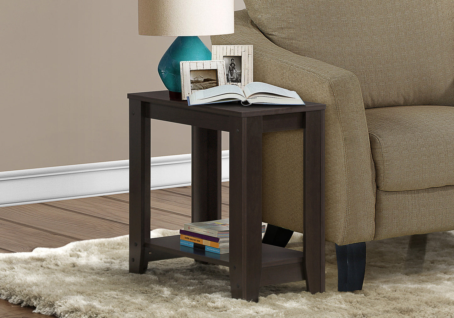 Dark brown end table with open book and picture frames on top