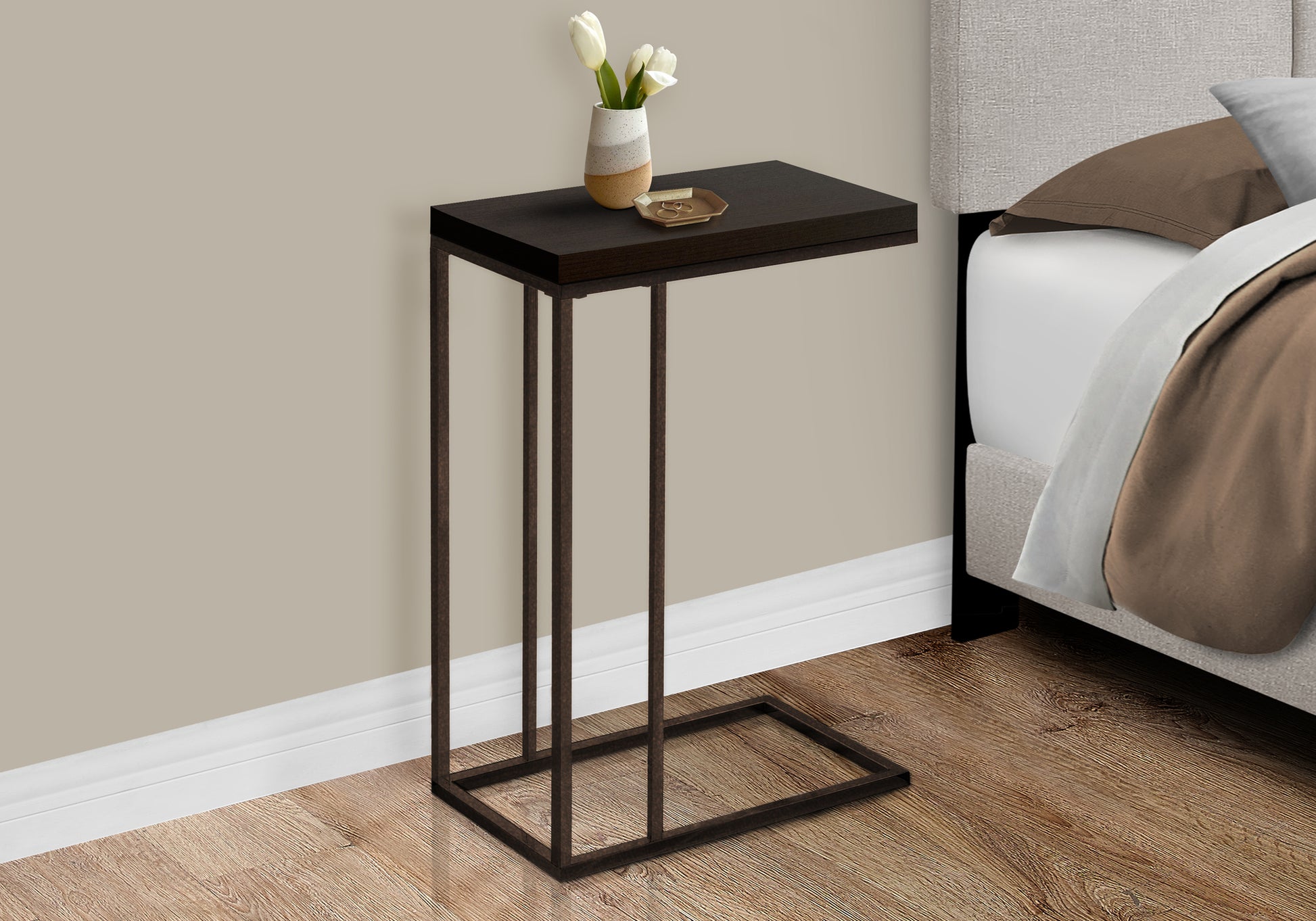 Dark wood Ctable with bronze metal frame next to bed perfect for remote storage