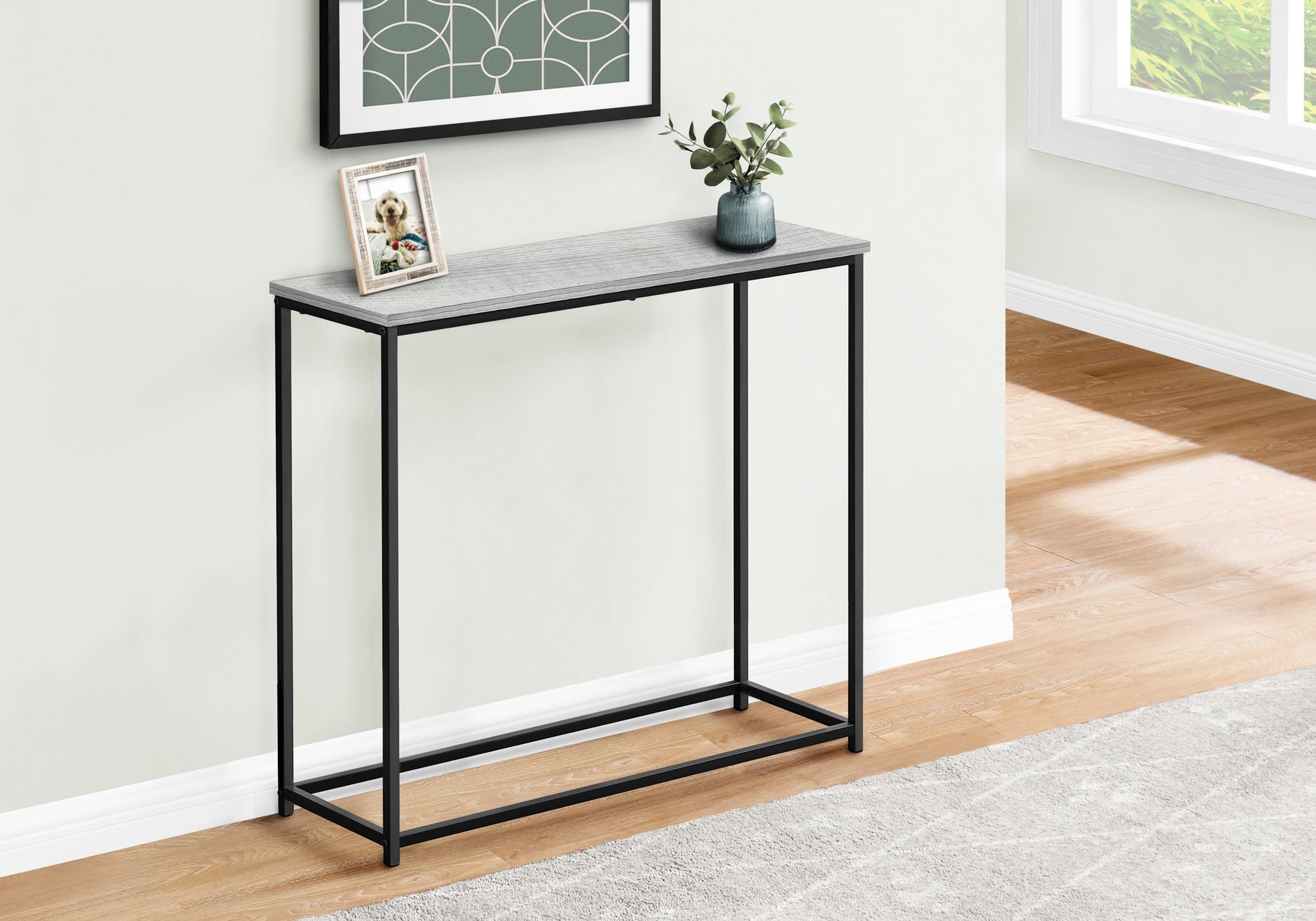 Slim gray wood grain console table with black metal frame and decorative accents