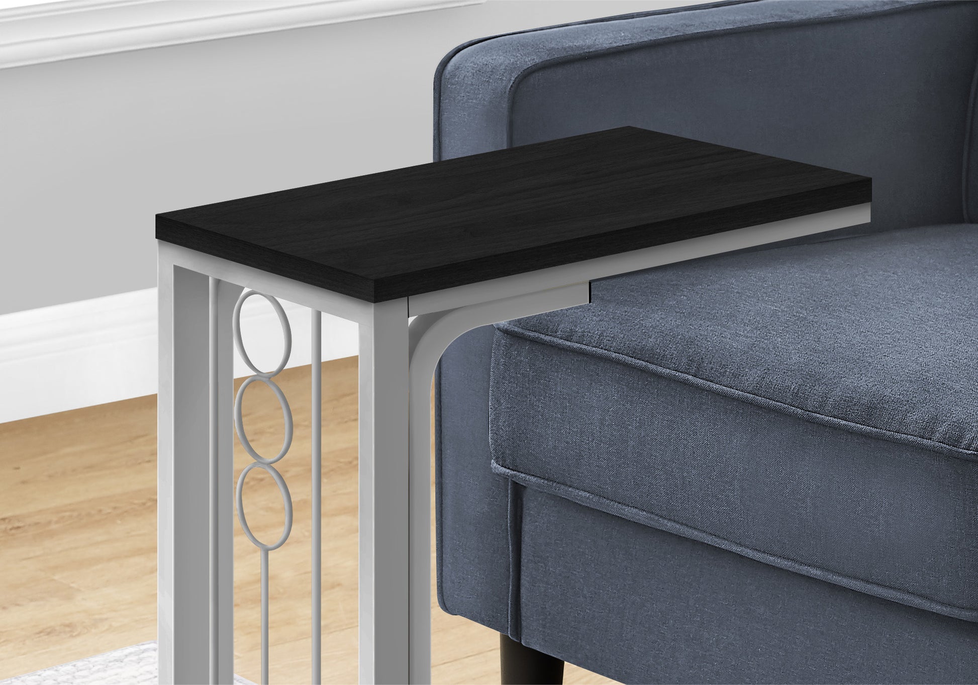 Black wooden ctable with metal frame and decorative rings beside blue armchair