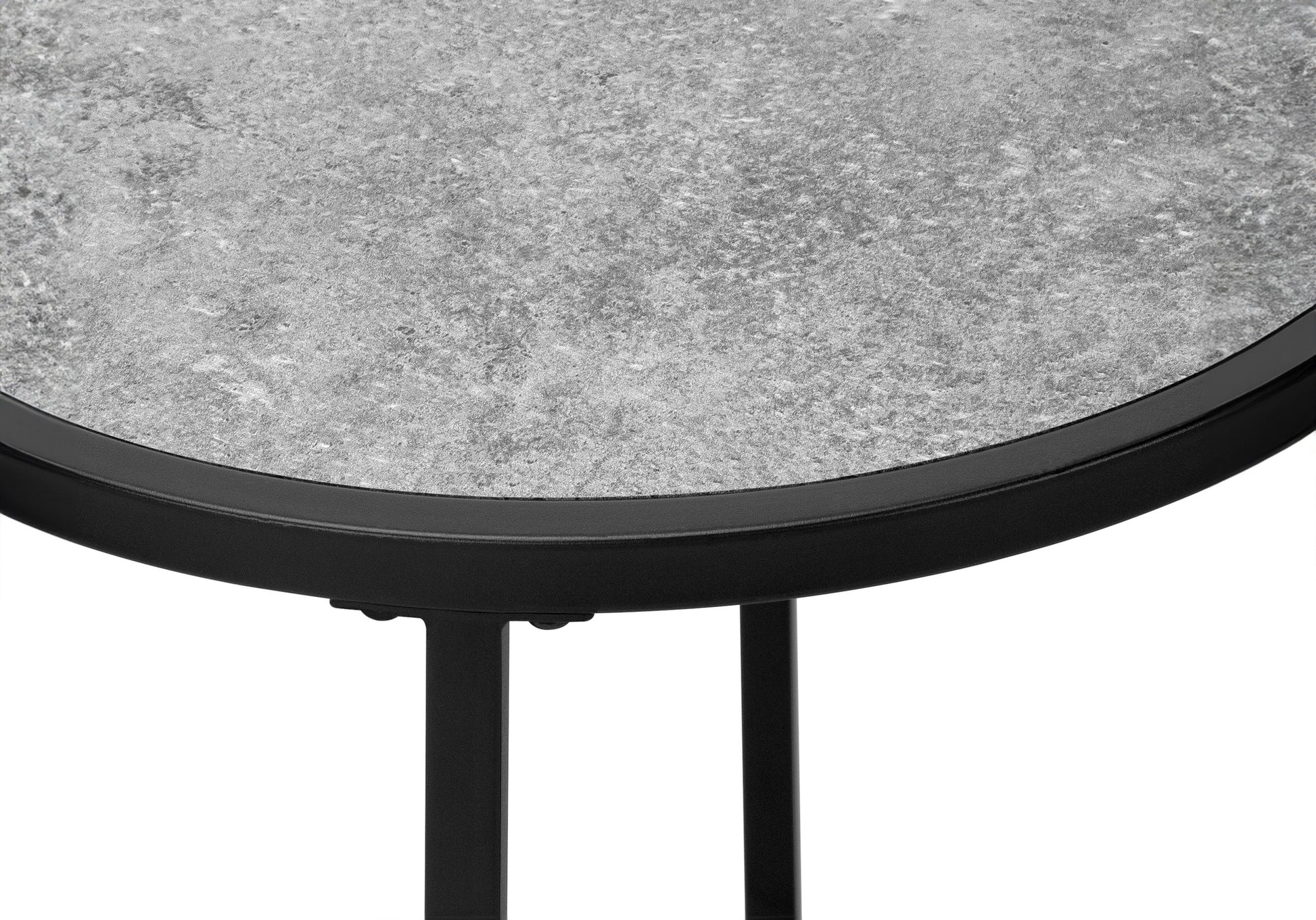 Closeup of a speckled grey textured tabletop with a black metal rim and legs