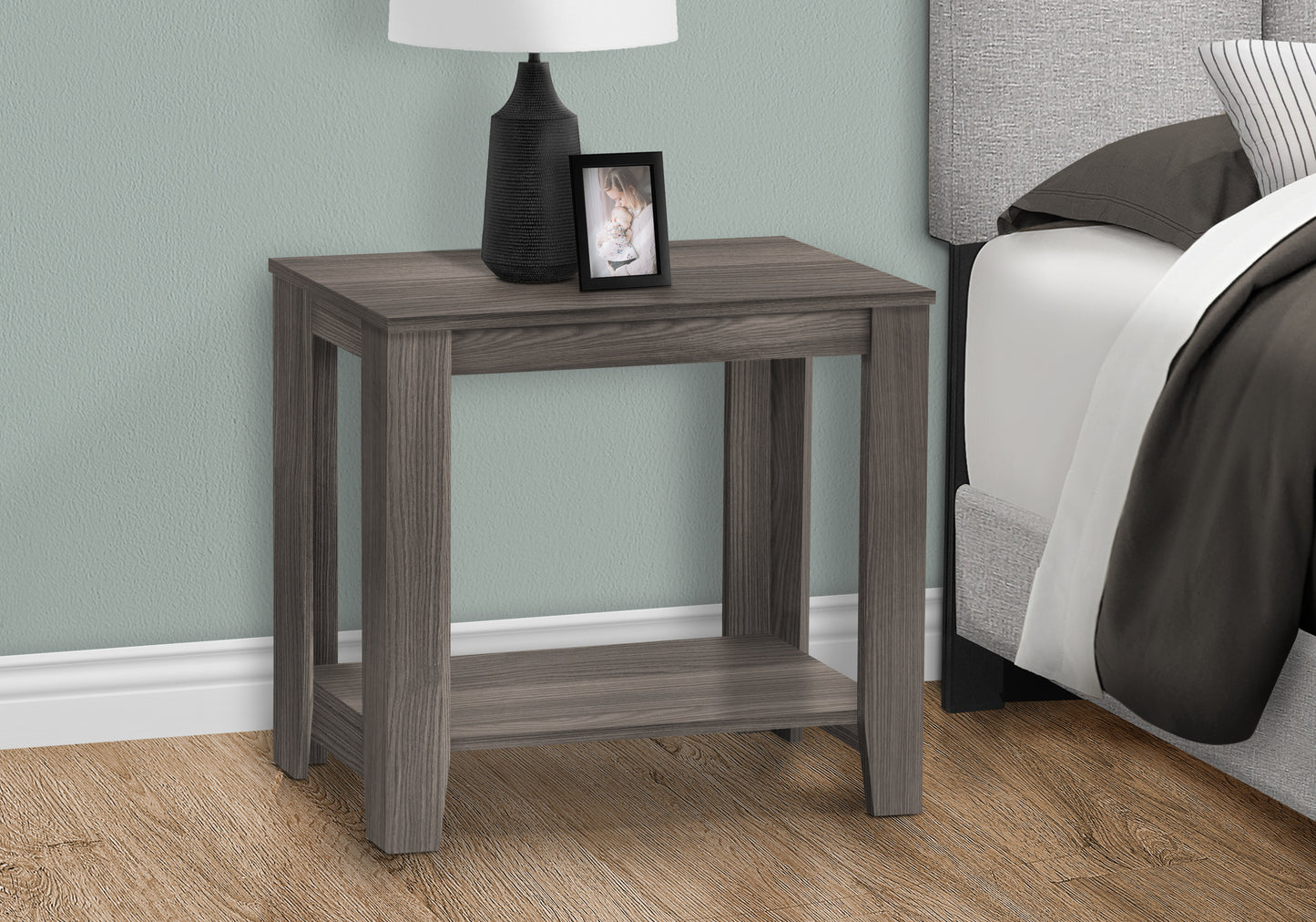Gray wood bedside table with a lower shelf and a framed picture of a mother and child