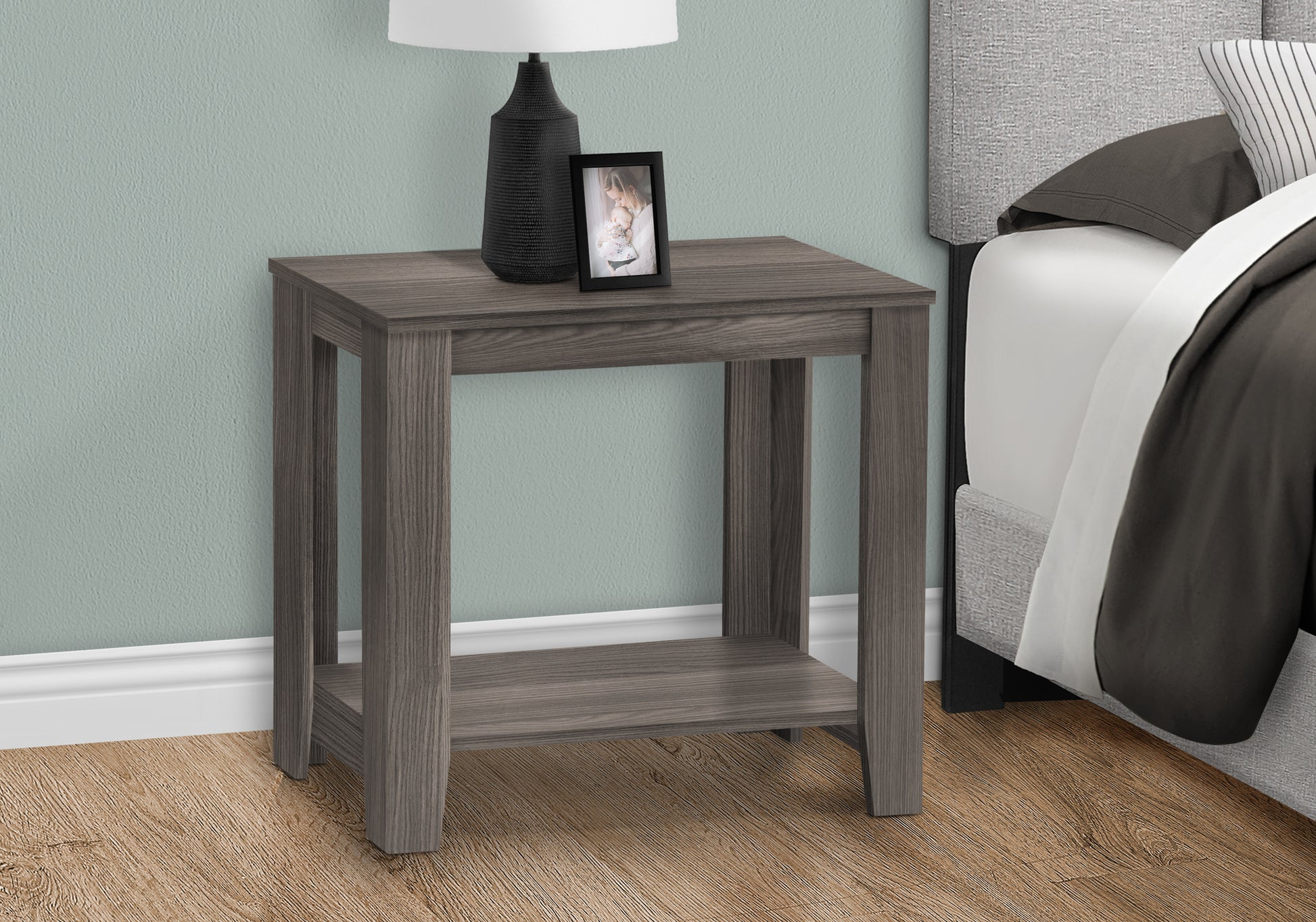 Gray wood bedside table with a lower shelf and a framed picture of a mother and child