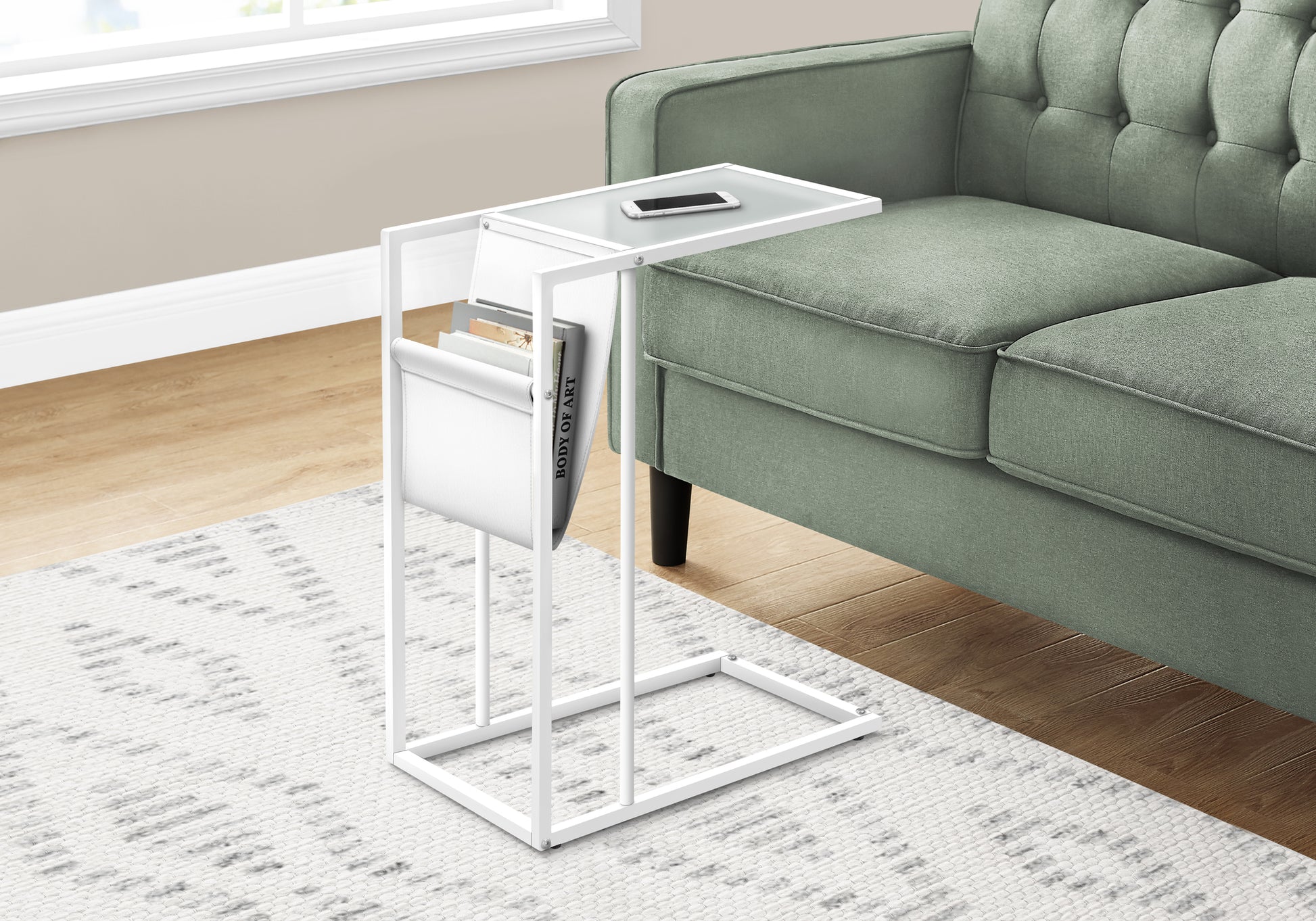 White ctable with frosted glass top holding a smartphone next to a green sofa