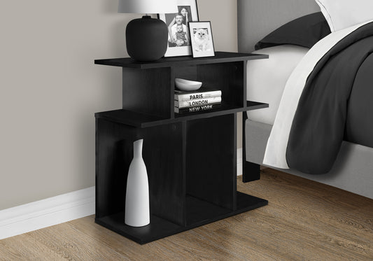 Black modern nightstand with open shelving a lamp framed photos and decor