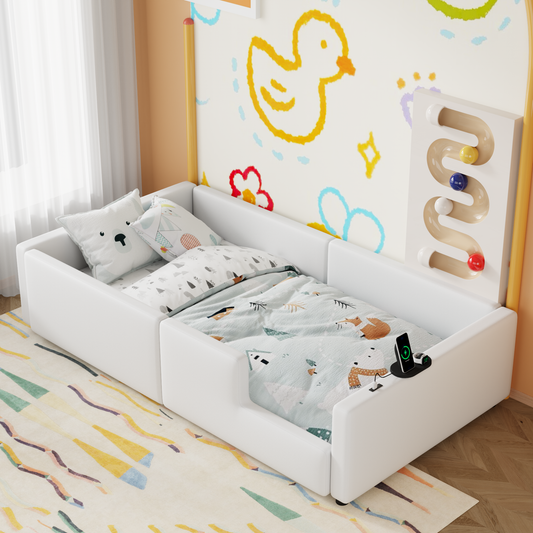 White toddler bed with playful animal bedding and a charging station