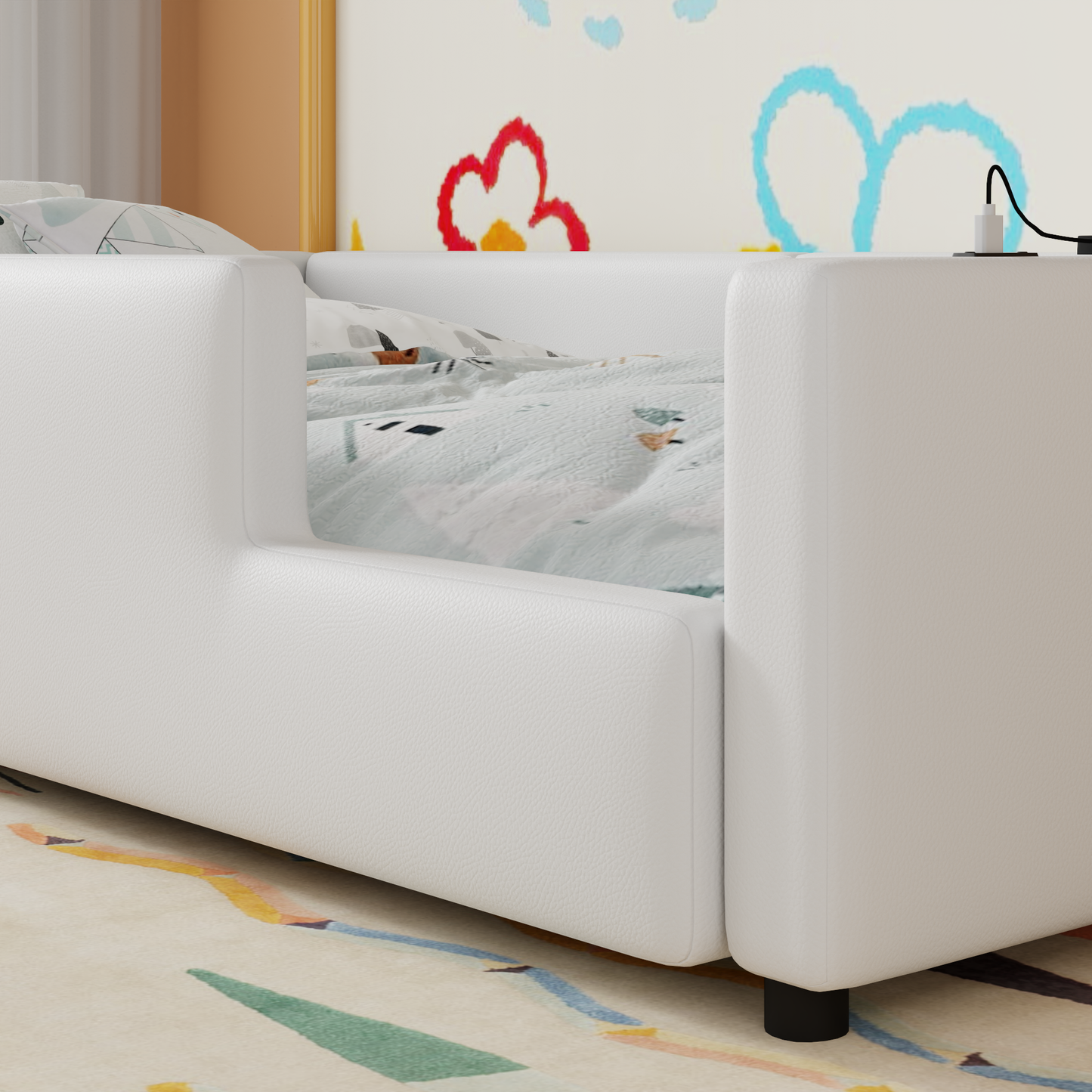 White leather toddler bed with fun patterned bedding and a charging station