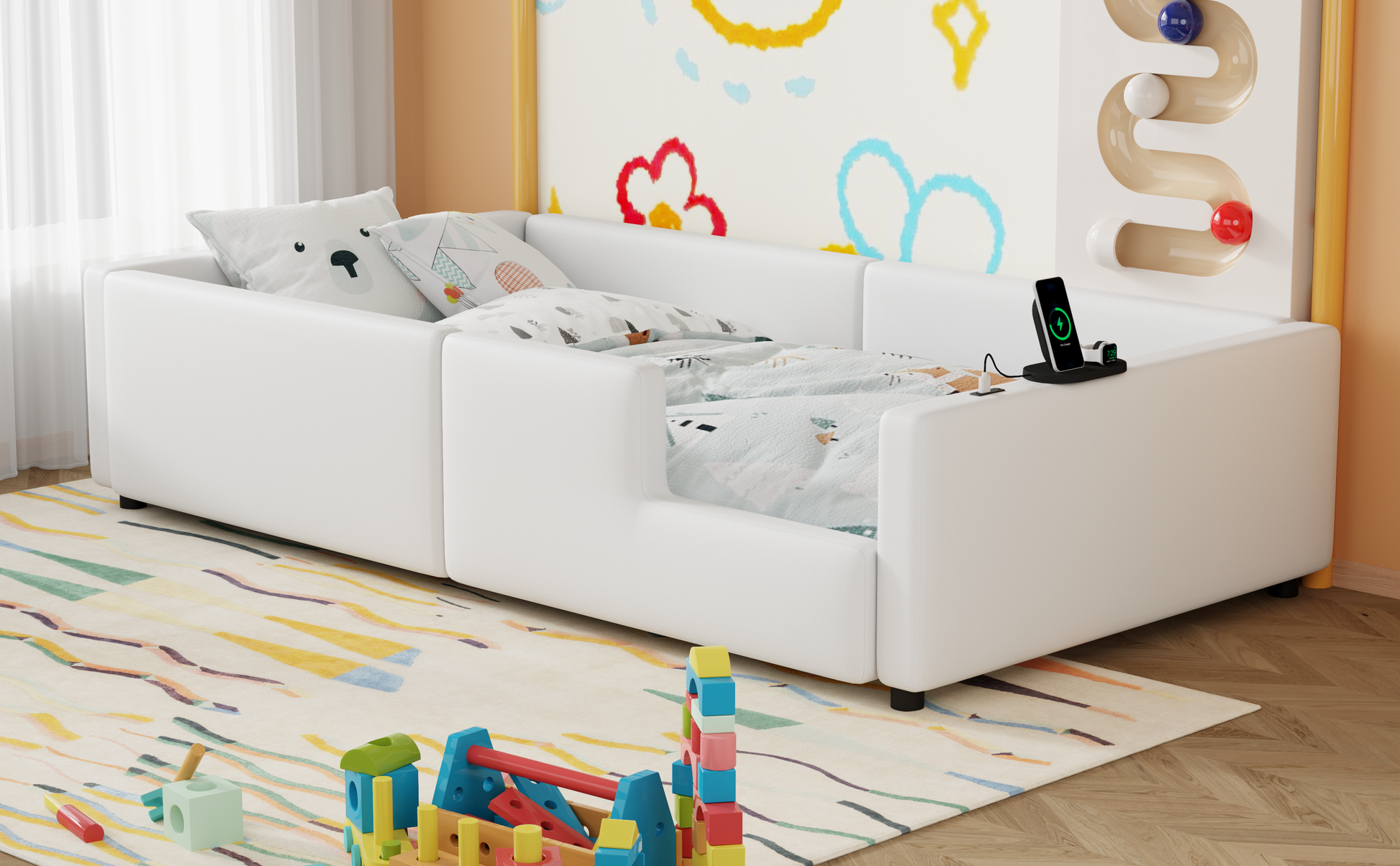 White faux leather toddler bed with playful pillows and charging station