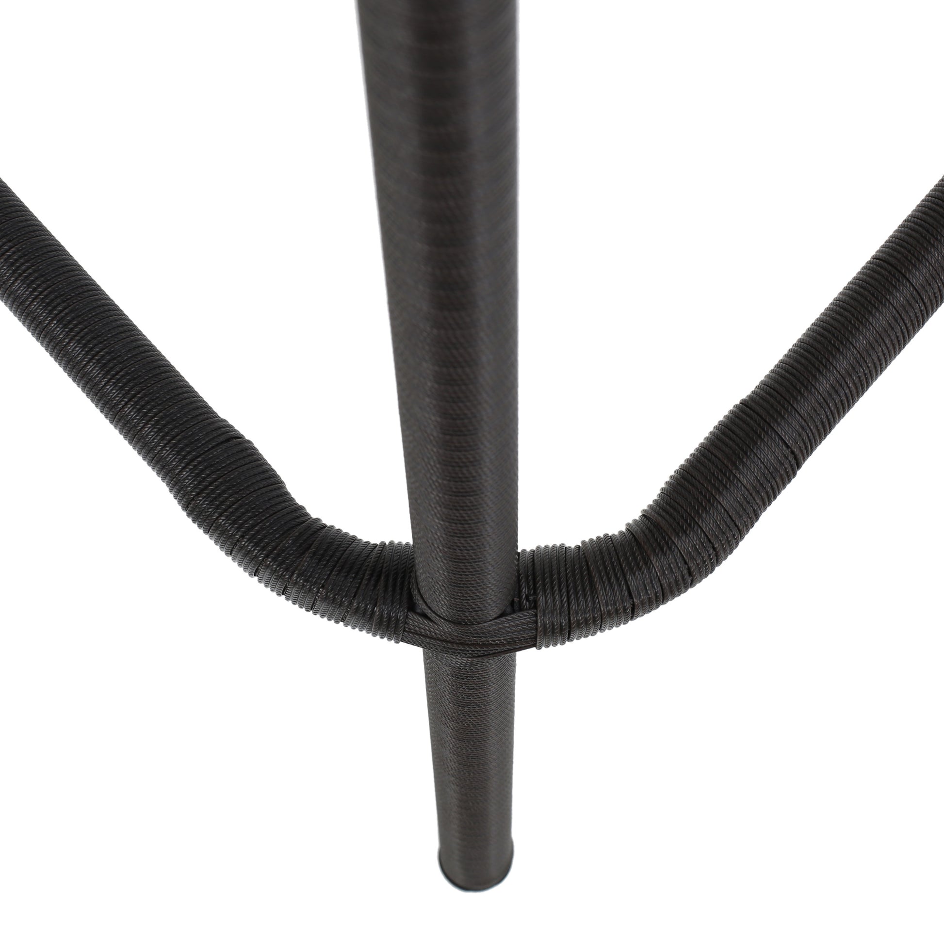 Closeup of dark brown woven rattan texture on a chair leg