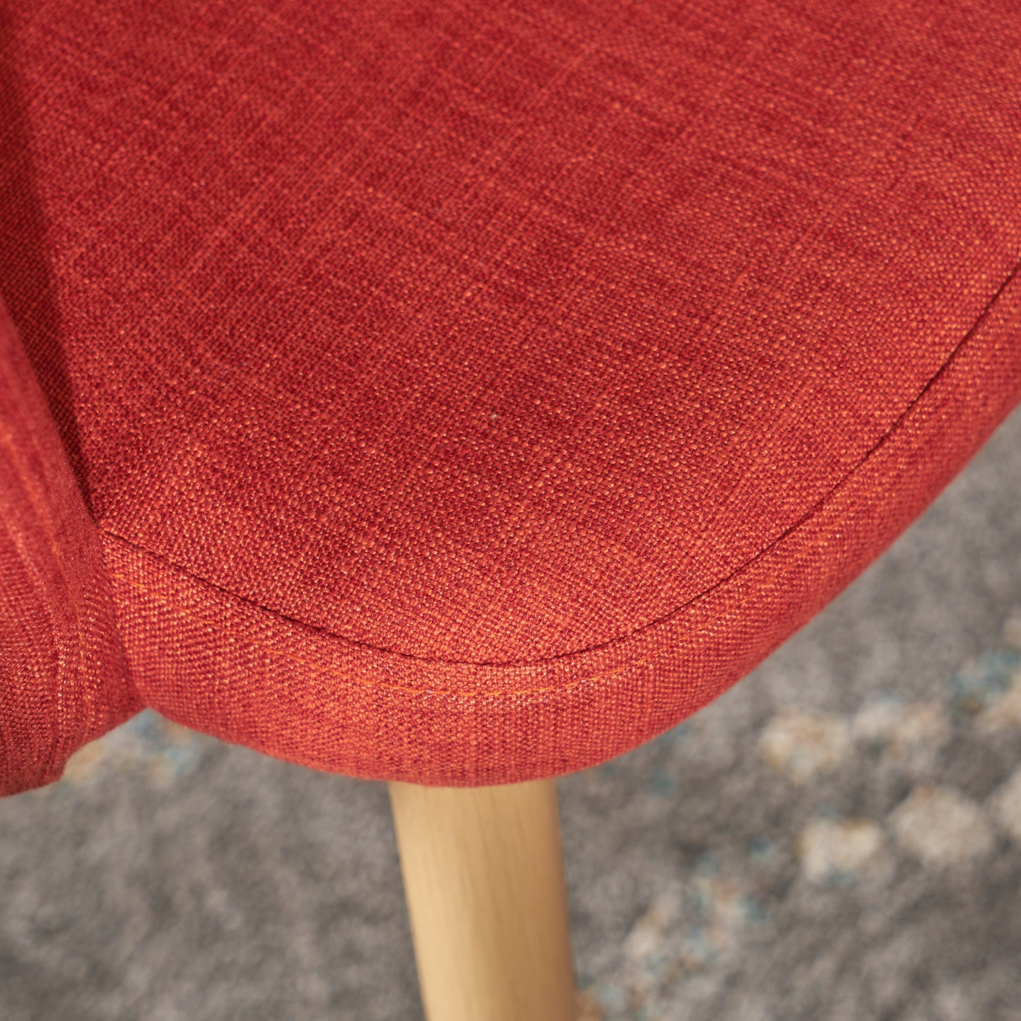 Closeup of burnt orange textured fabric on a modern chair seat