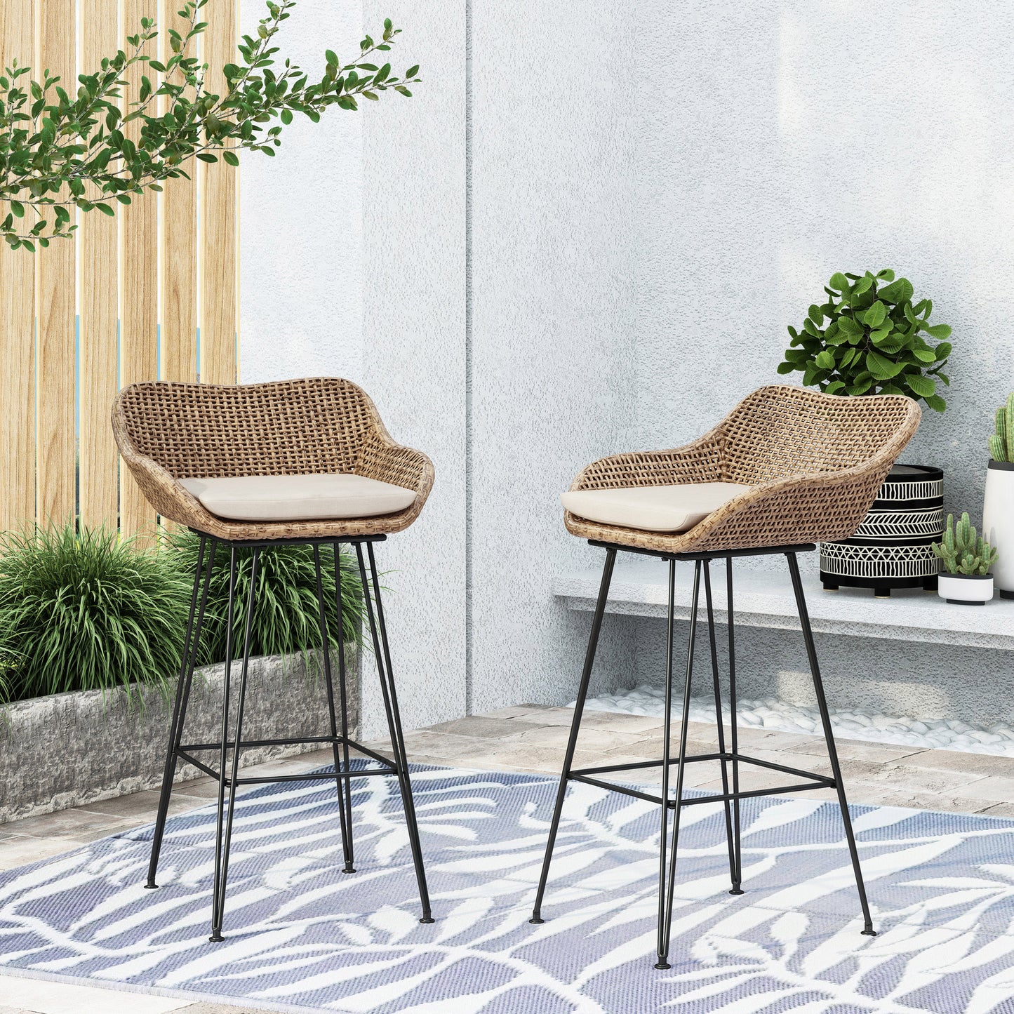 Woven rattan bar stool with a cream cushion and black metal legs ideal for modern patio decor