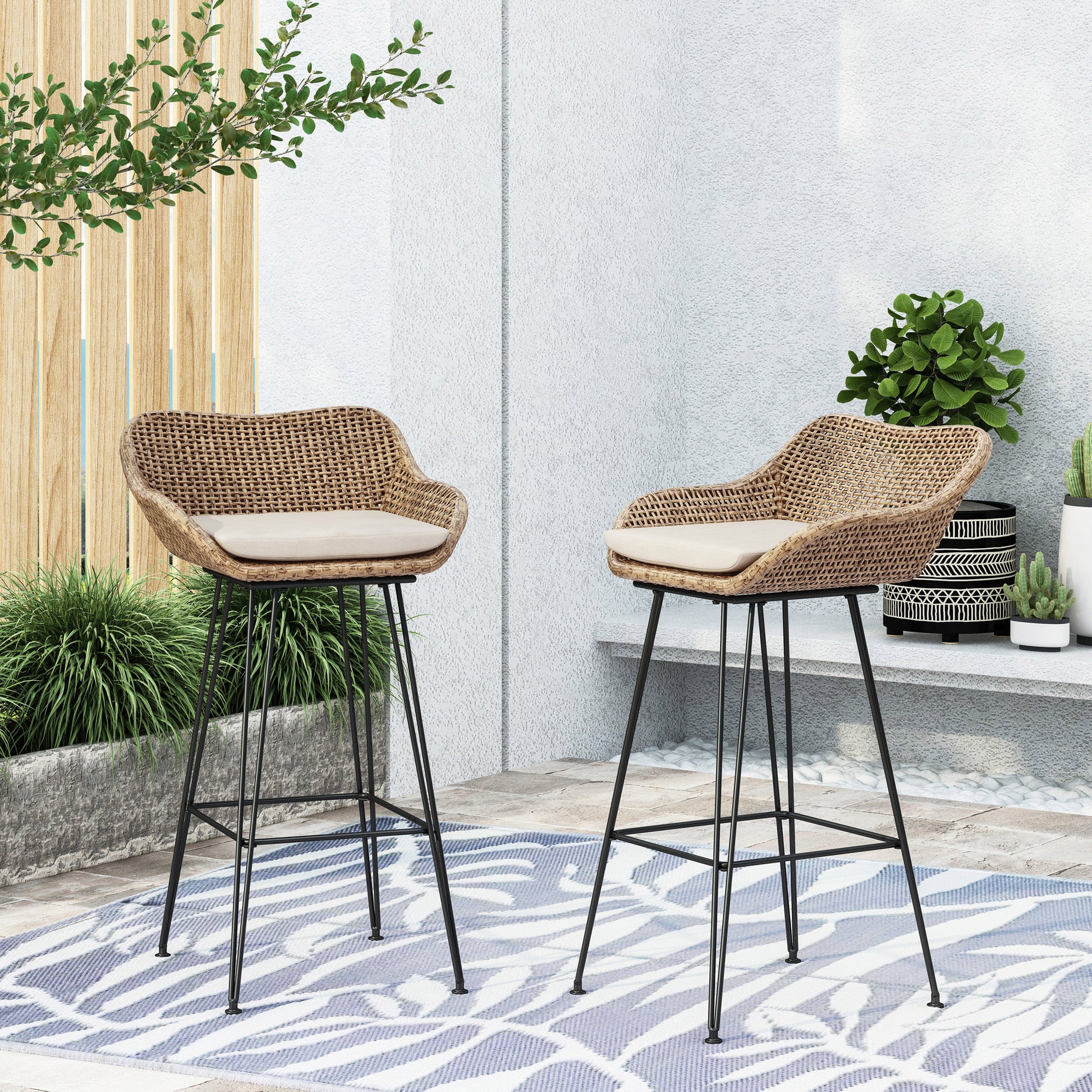 Woven rattan bar stool with a cream cushion and black metal legs ideal for modern patio decor