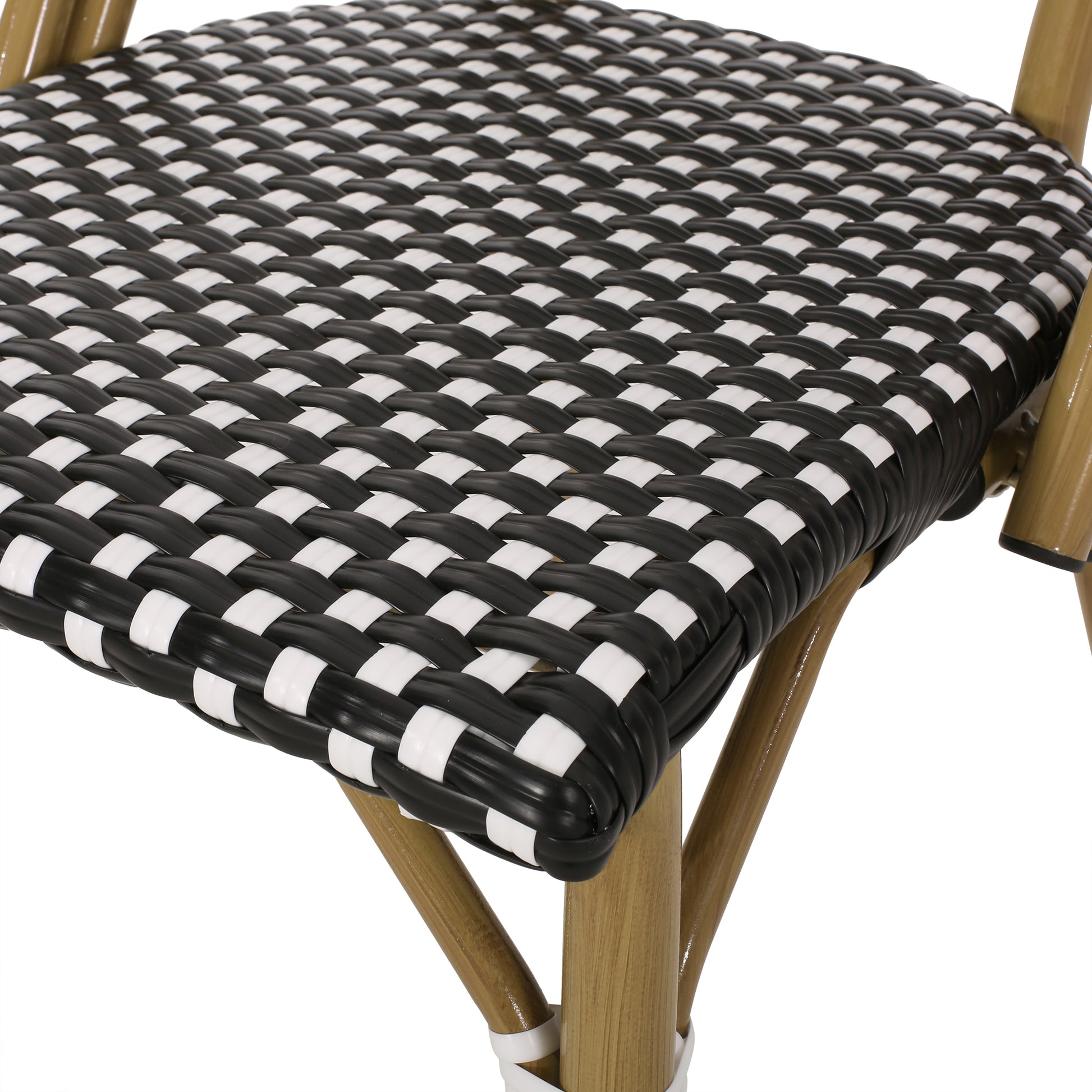 Closeup of a black and white rattan cafe chair seat with natural wood legs