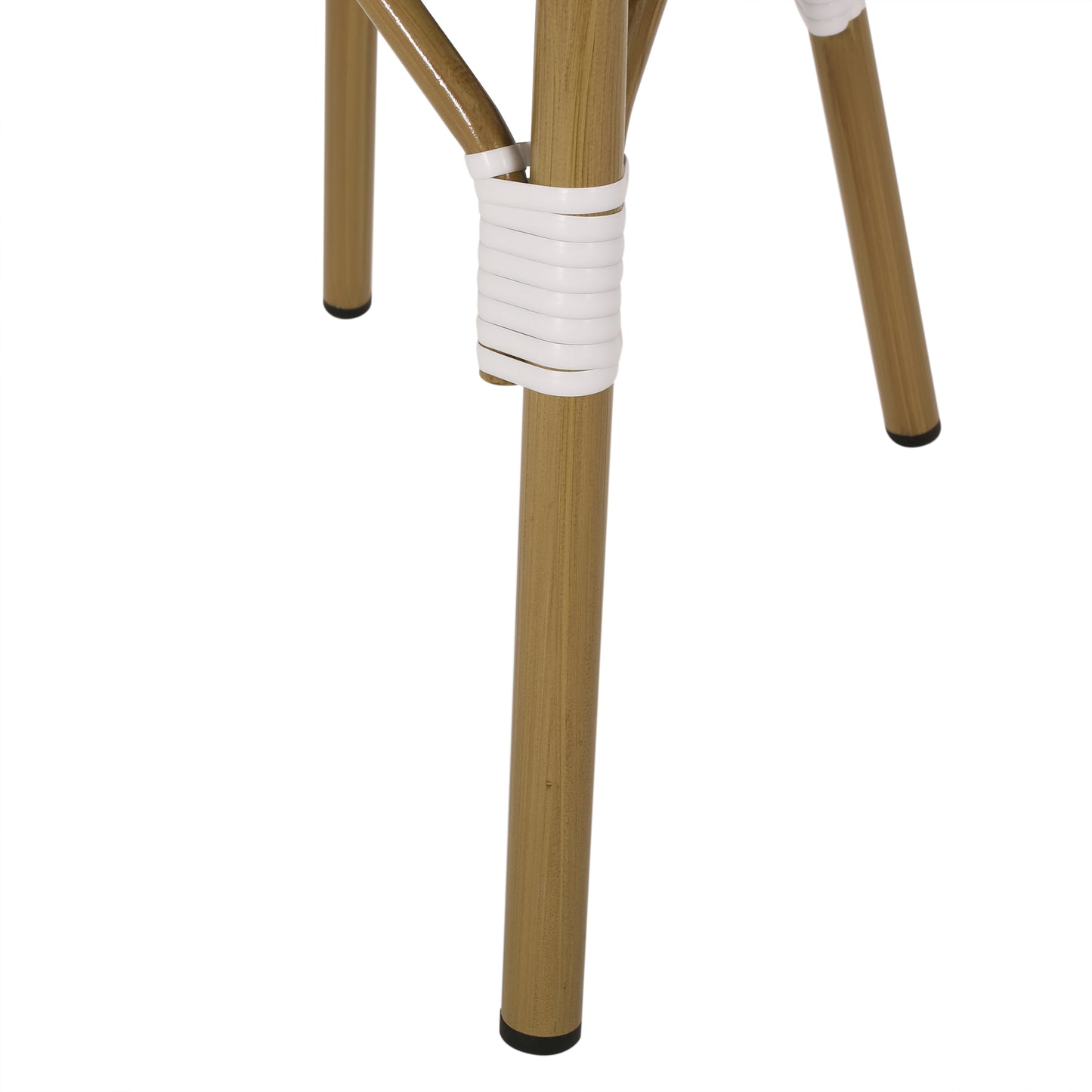 Closeup of gold metal chair legs with white rattan wrapping detail