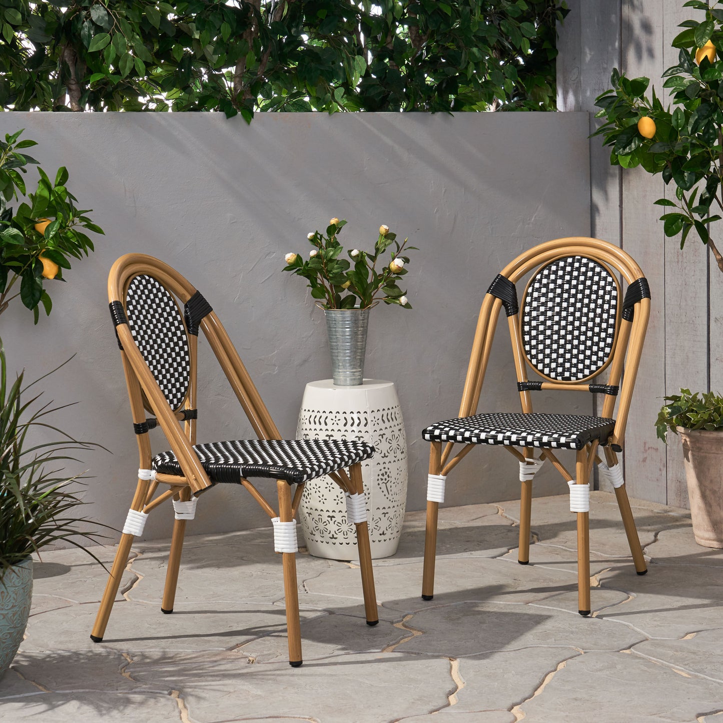 Two bamboo bistro chairs with black and white checkered seats and backs perfect for outdoor dining