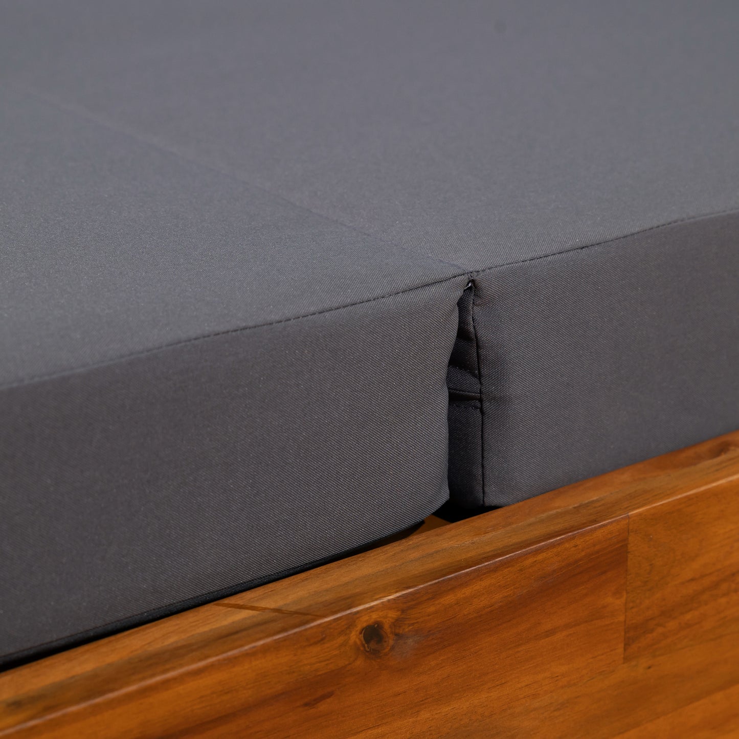 Closeup of charcoal gray outdoor cushion fabric on a wooden frame