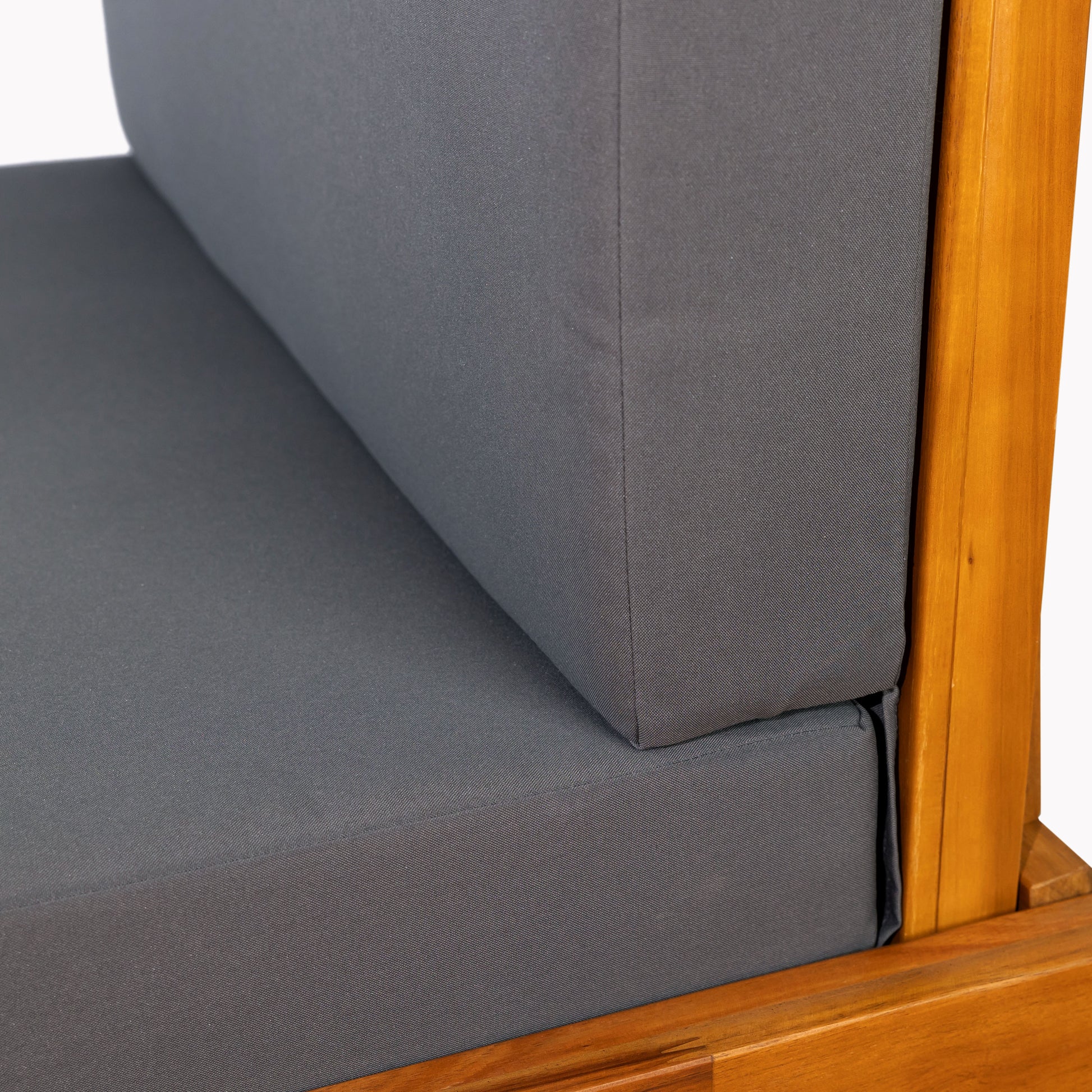 Closeup of grey outdoor furniture cushion with natural wood frame