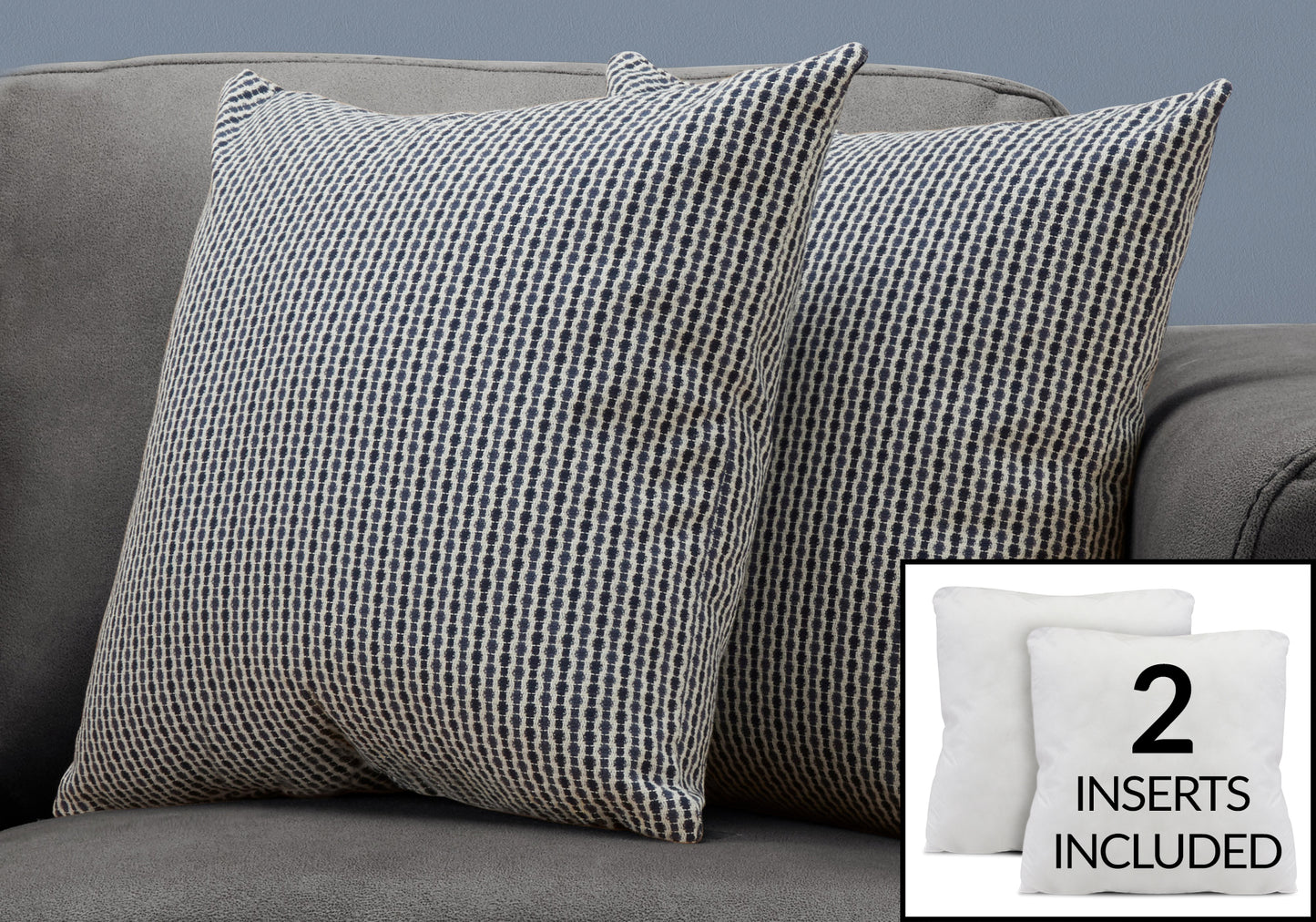 Two navy and cream geometric patterned throw pillows on a grey sofa
