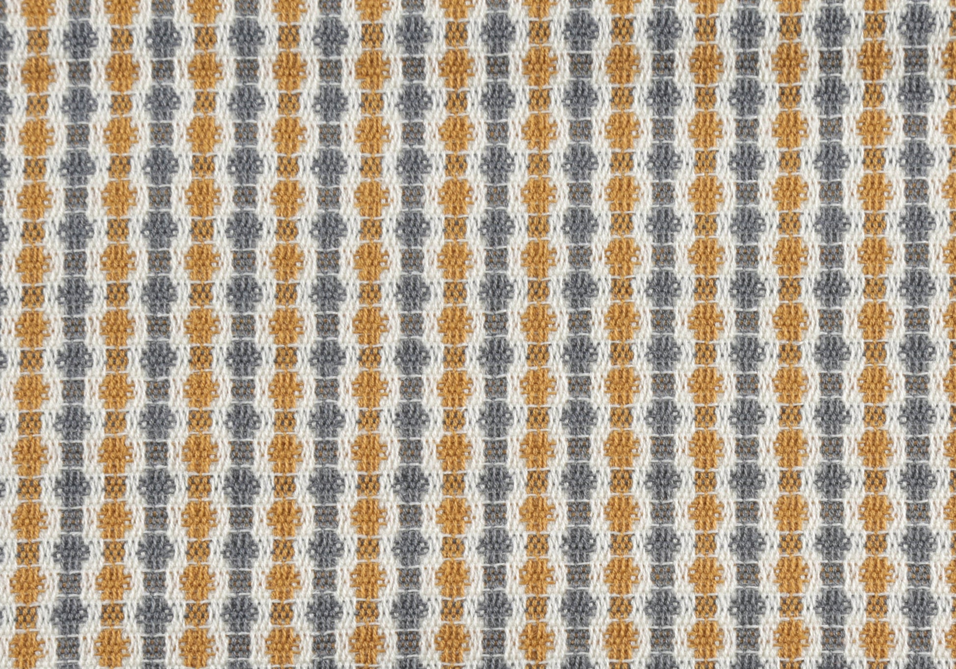 Closeup of a textured woven fabric featuring a repeating geometric pattern in mustard yellow charcoal gray and cream