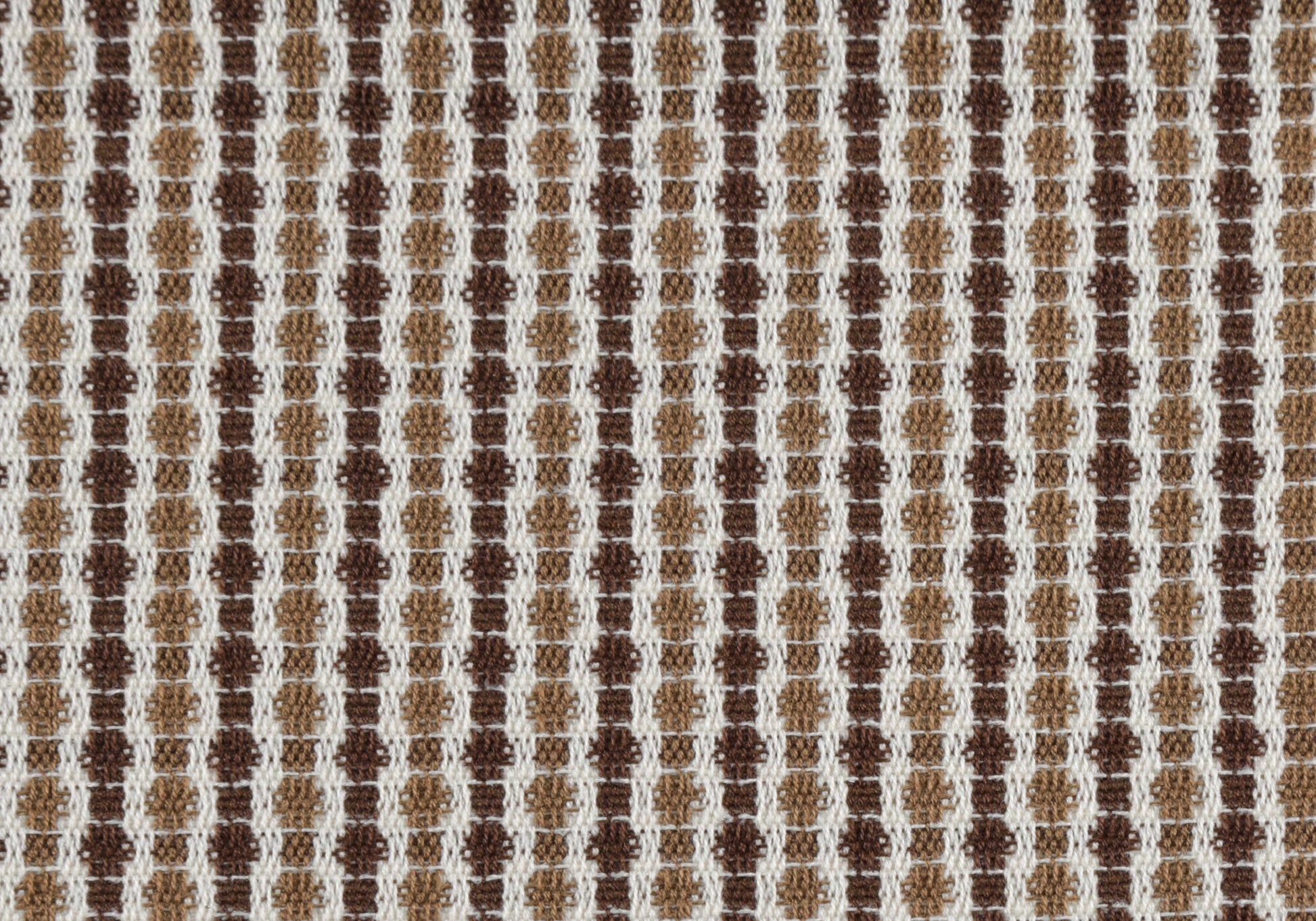 Woven fabric with a repeating geometric pattern of small squares in white light brown and dark brown