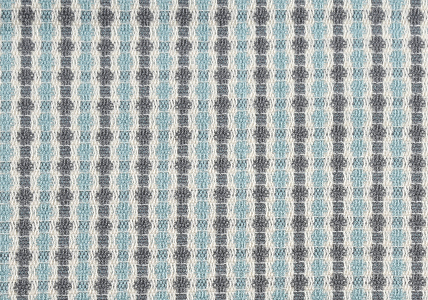 Closeup of white grey and light blue geometric woven fabric for upholstery