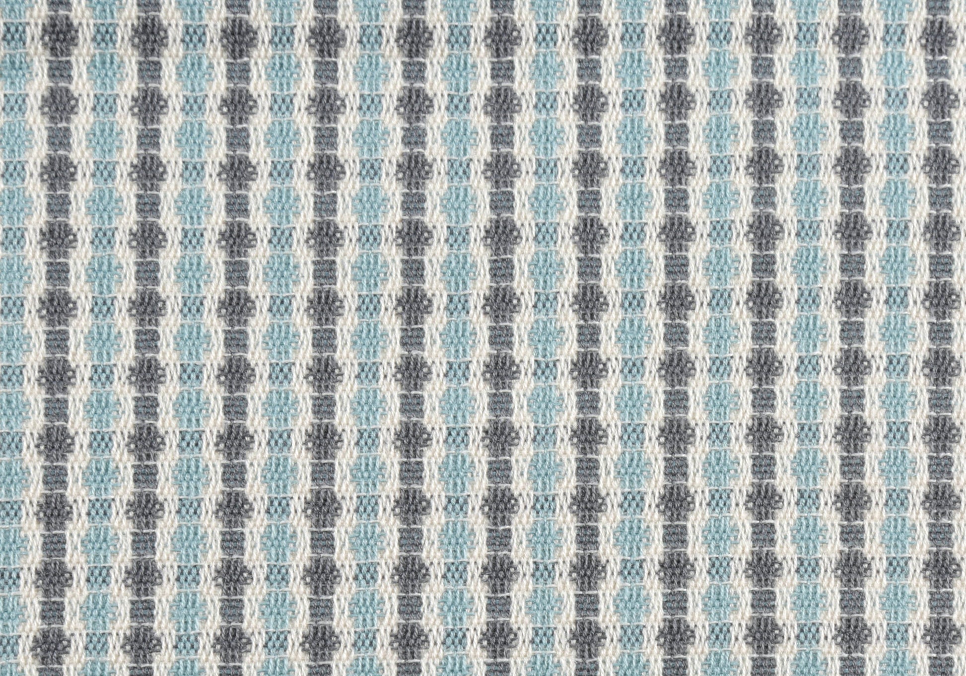Closeup of geometric woven fabric in light blue and grey diamond pattern